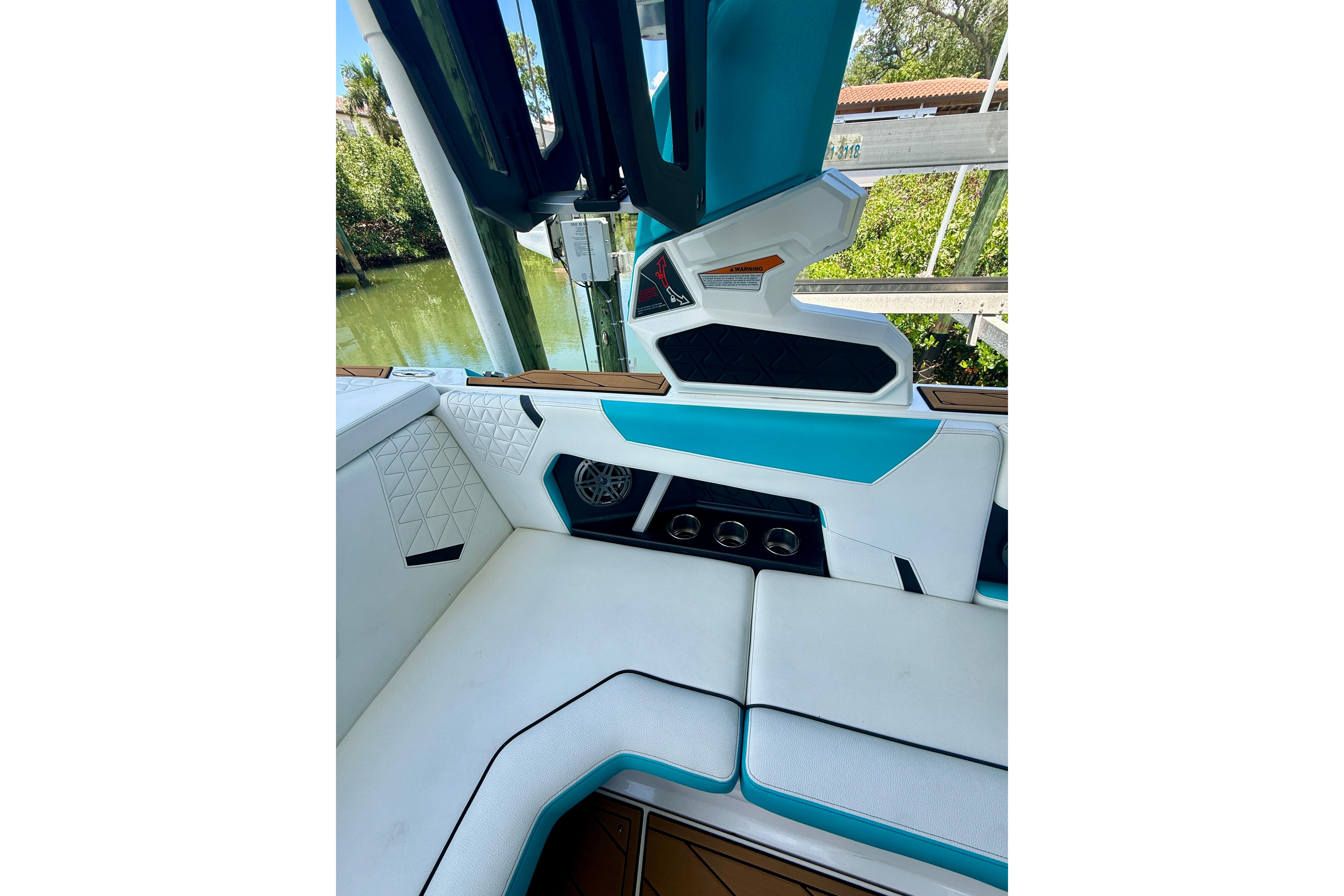 2024 Nautique Super Air Nautique GS20 interior with white and teal seating, cup holders, and speaker.