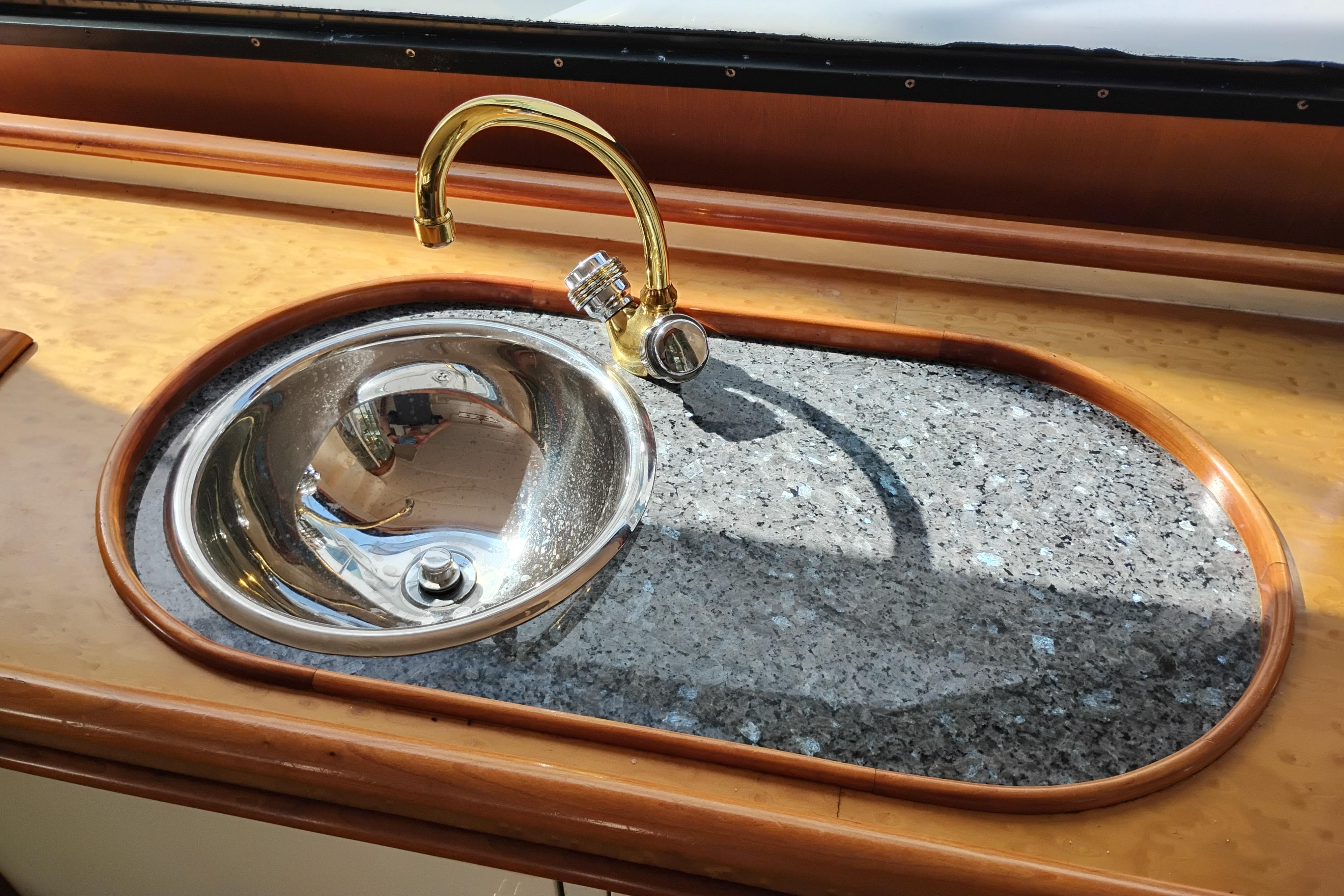 Luxurious sink with gold faucet on Queenship 62 Pilothouse Motor Yacht, 1995 model.