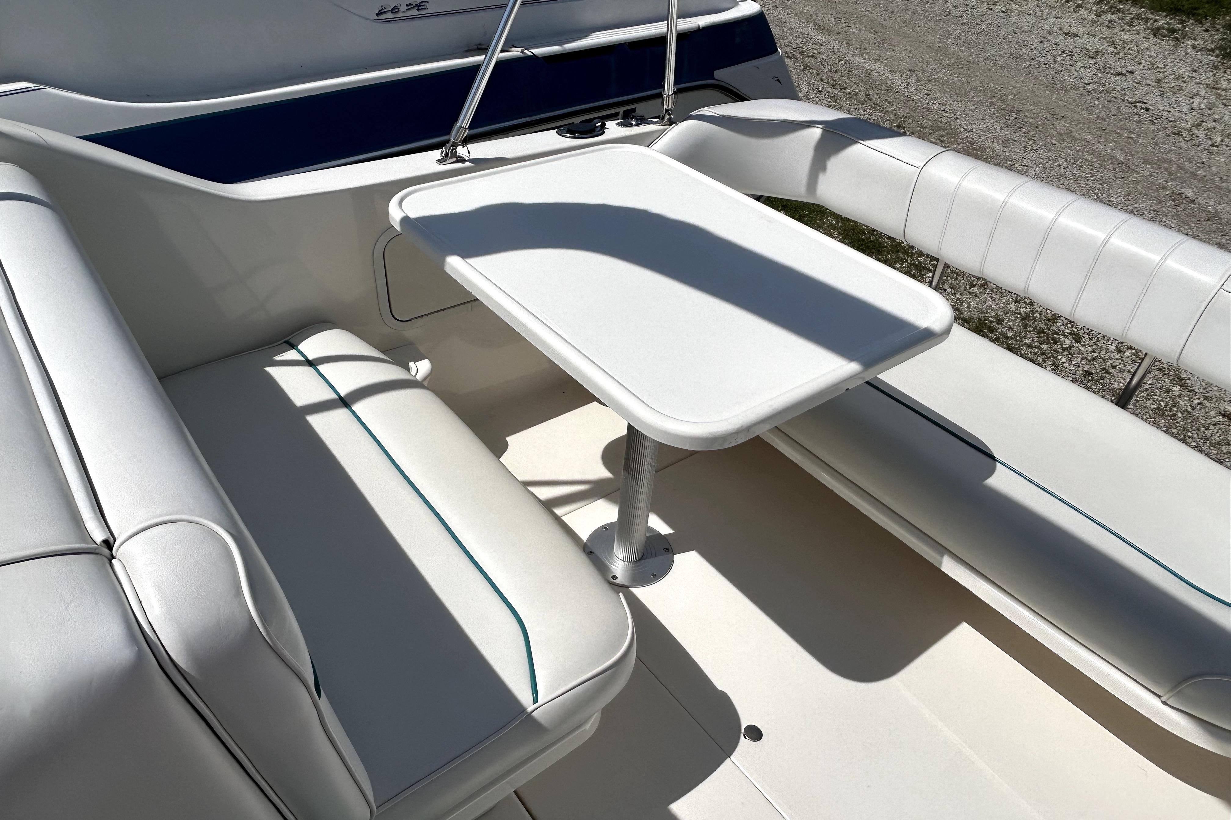 Interior seating area of a 1995 Sea Ray 250 Sundancer boat with white upholstery.