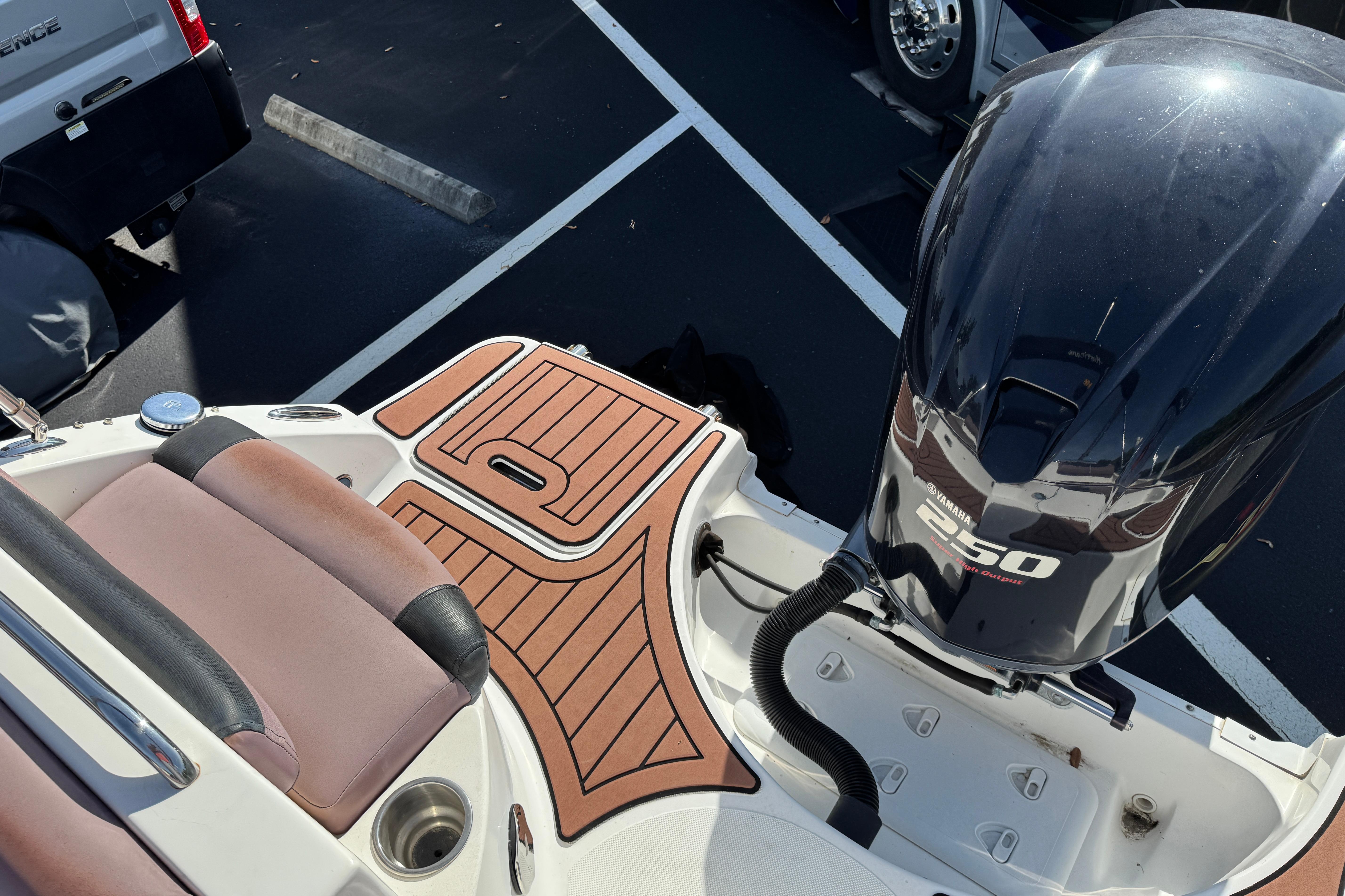 2018 Hurricane SunDeck 2400 OB boat with Yamaha 250 outboard motor, parked on asphalt.