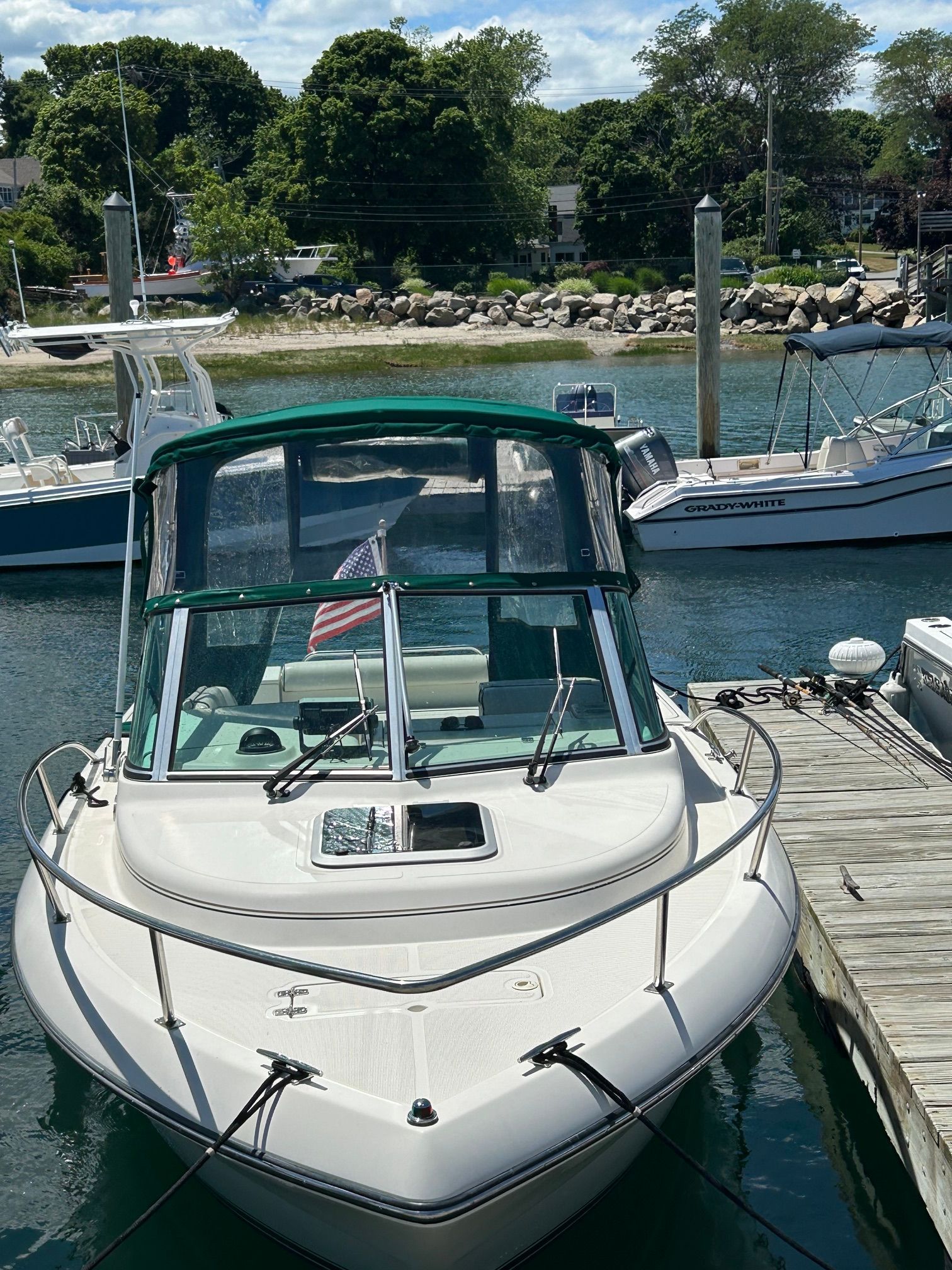 1999 Pursuit Denali boat docked with flag.
