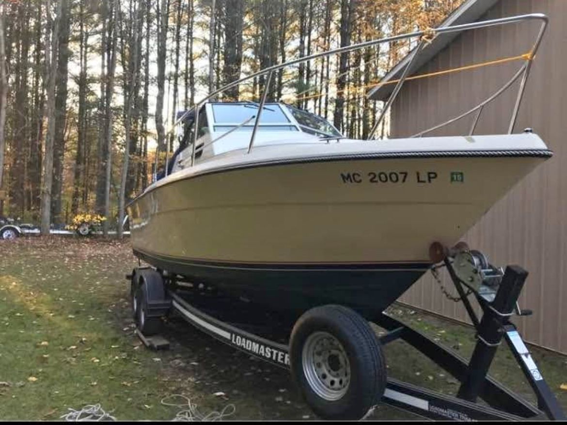 1984 Tiara Yachts PURSUIT 2600 on trailer in wooded area.