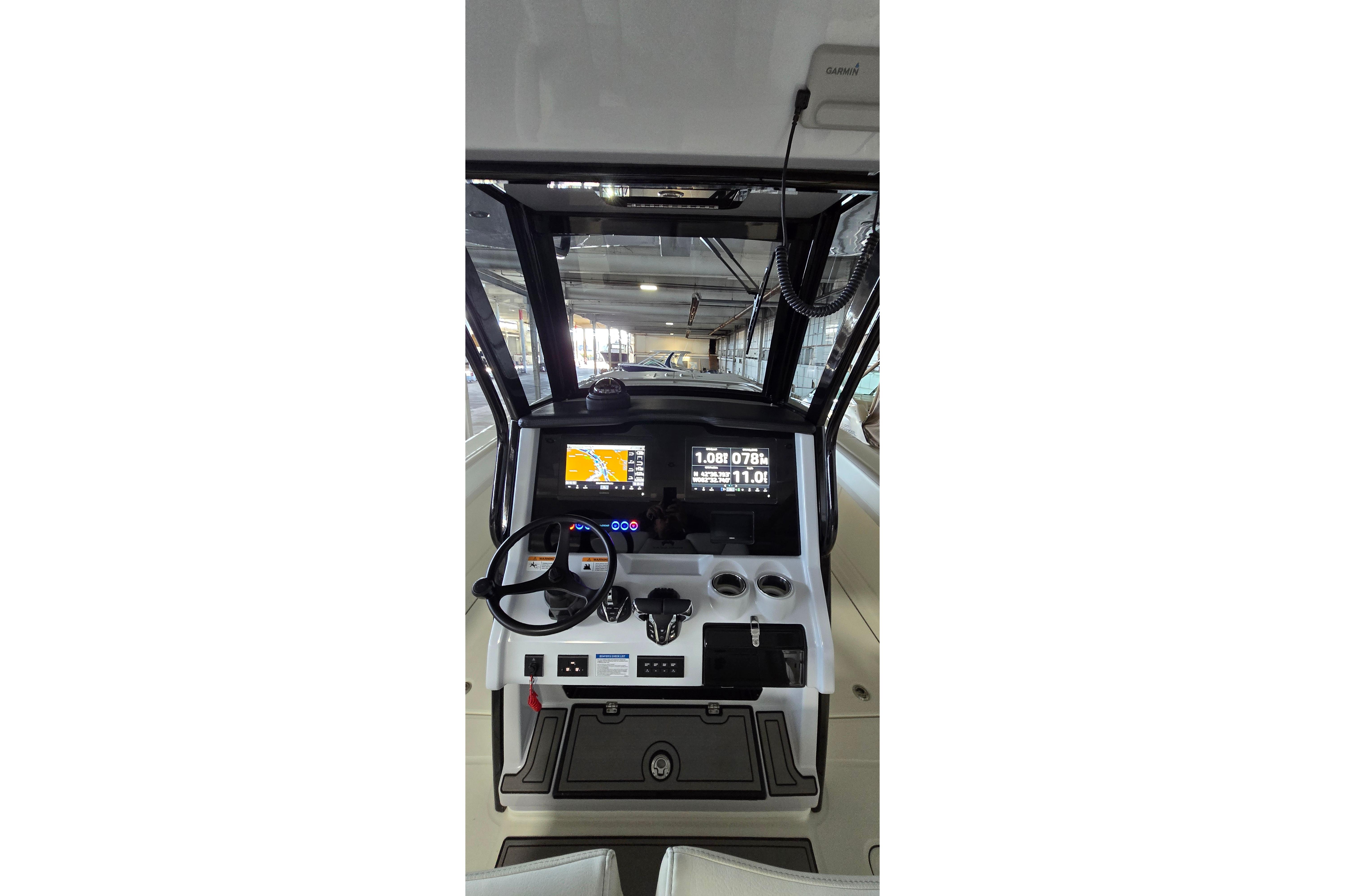 2024 WorldCat 280 CC-X boat dashboard with navigation screens and steering wheel.