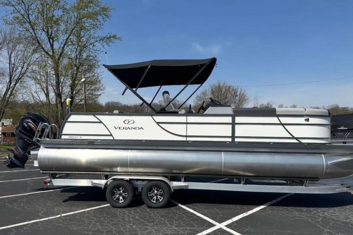 2025 Veranda Relax VR25VLC pontoon boat on trailer, parked outdoors under clear sky.