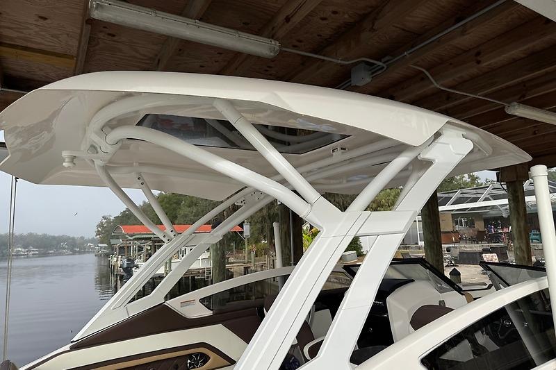 2023 Yamaha 275SDX boat with sleek white canopy docked under a wooden roof.