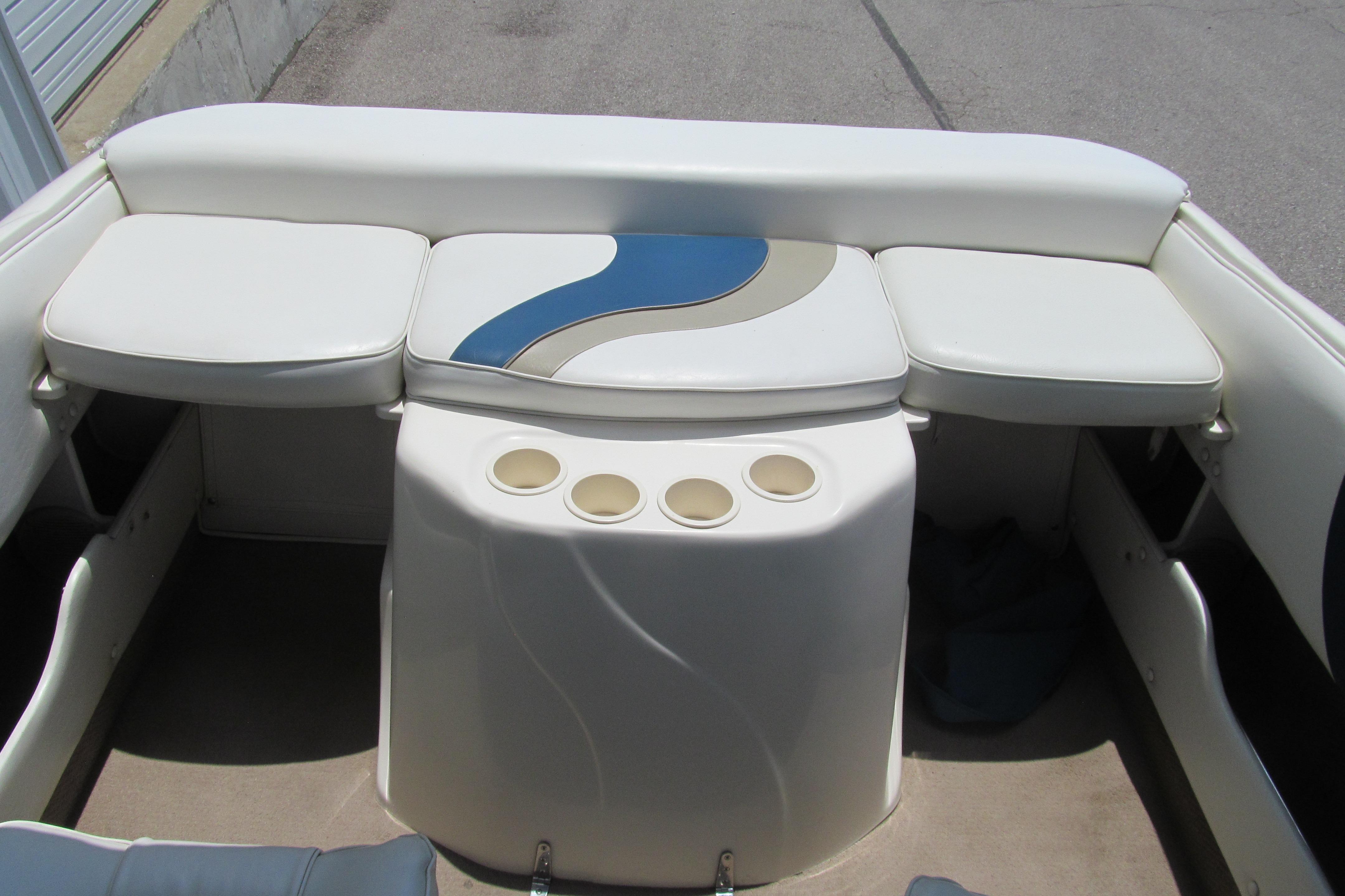 Interior of a 2000 Rinker boat featuring white seating and cup holders.