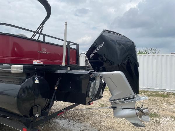 2023 Regency 250DL3 boat with Mercury outboard motor, parked on gravel.