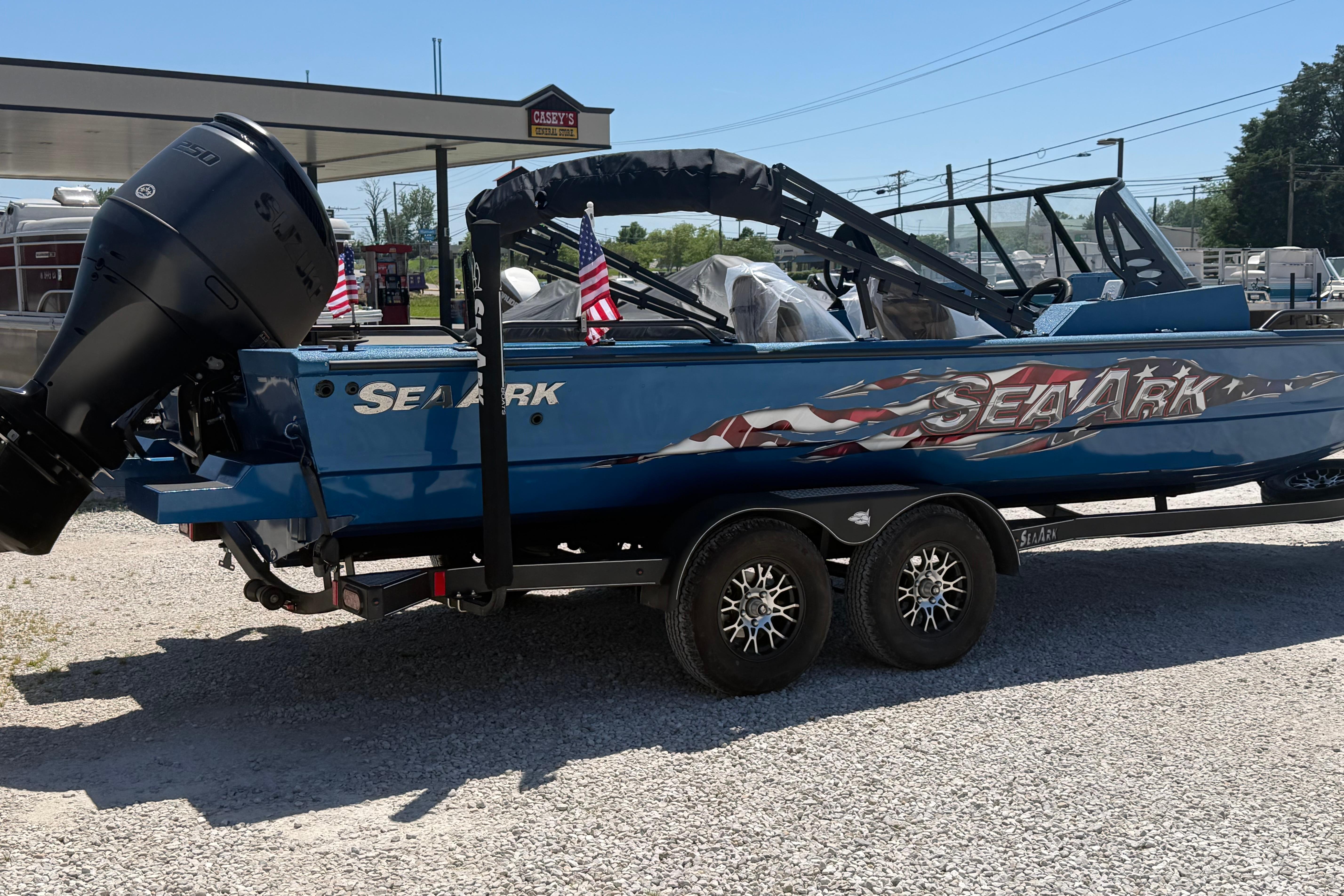 2025 SeaArk Protege 240 boat on trailer, blue with American flag graphics.