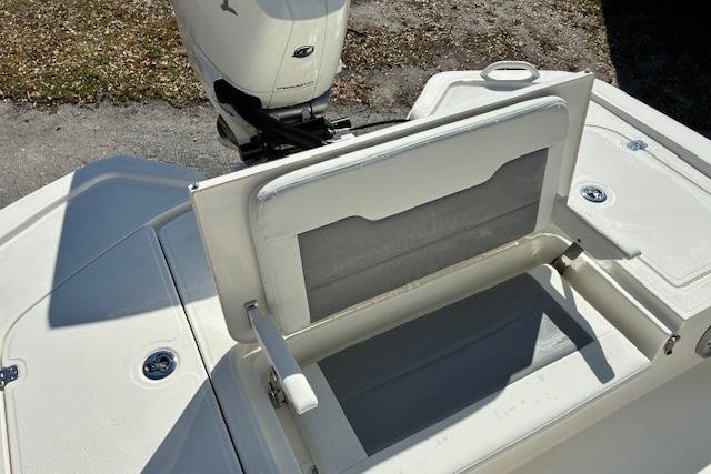 2026 Mako 24 APEX boat with open storage compartment and outboard motor.