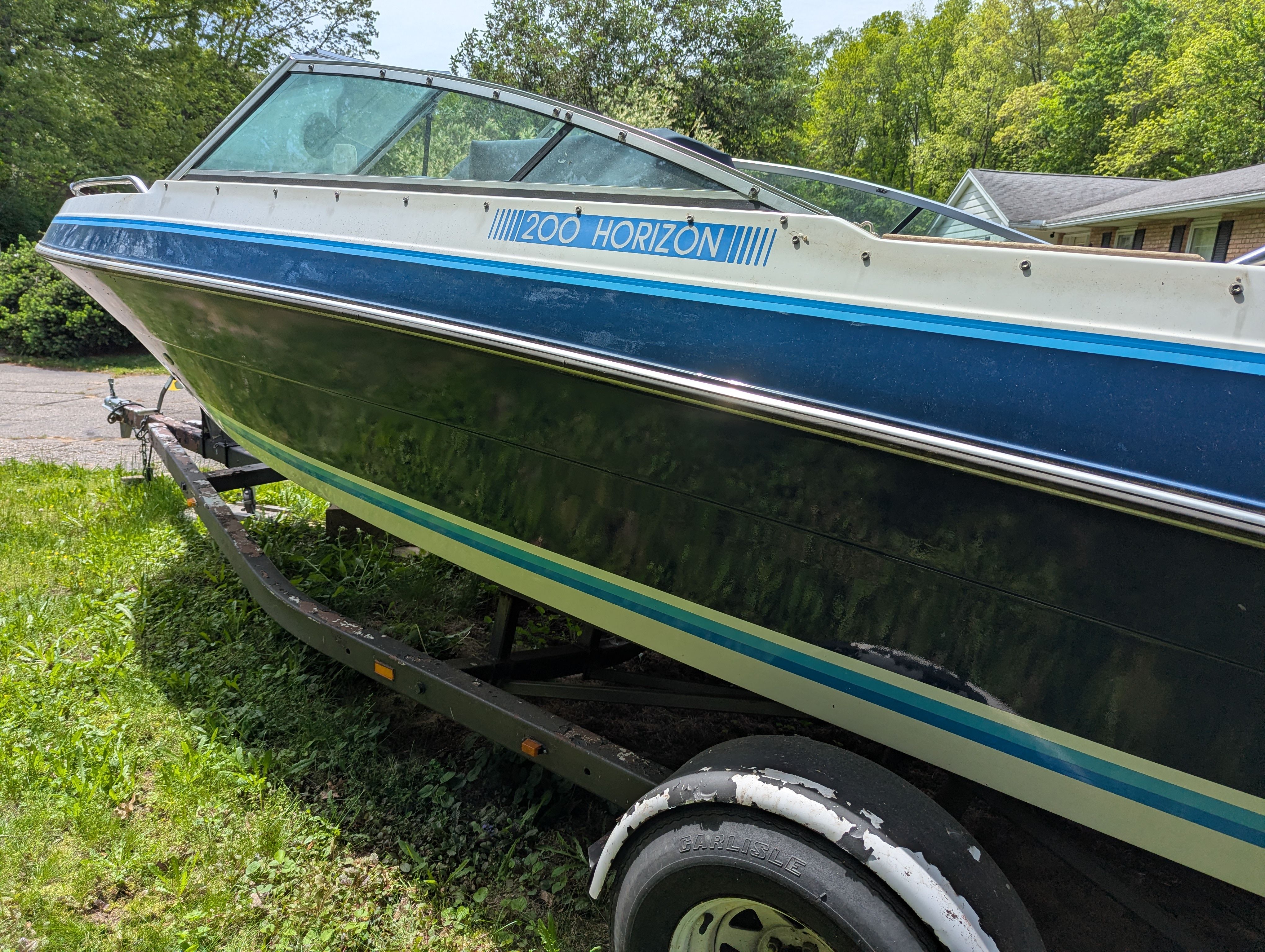 1988 Four Winns 200 Horizon boat on trailer outdoors.