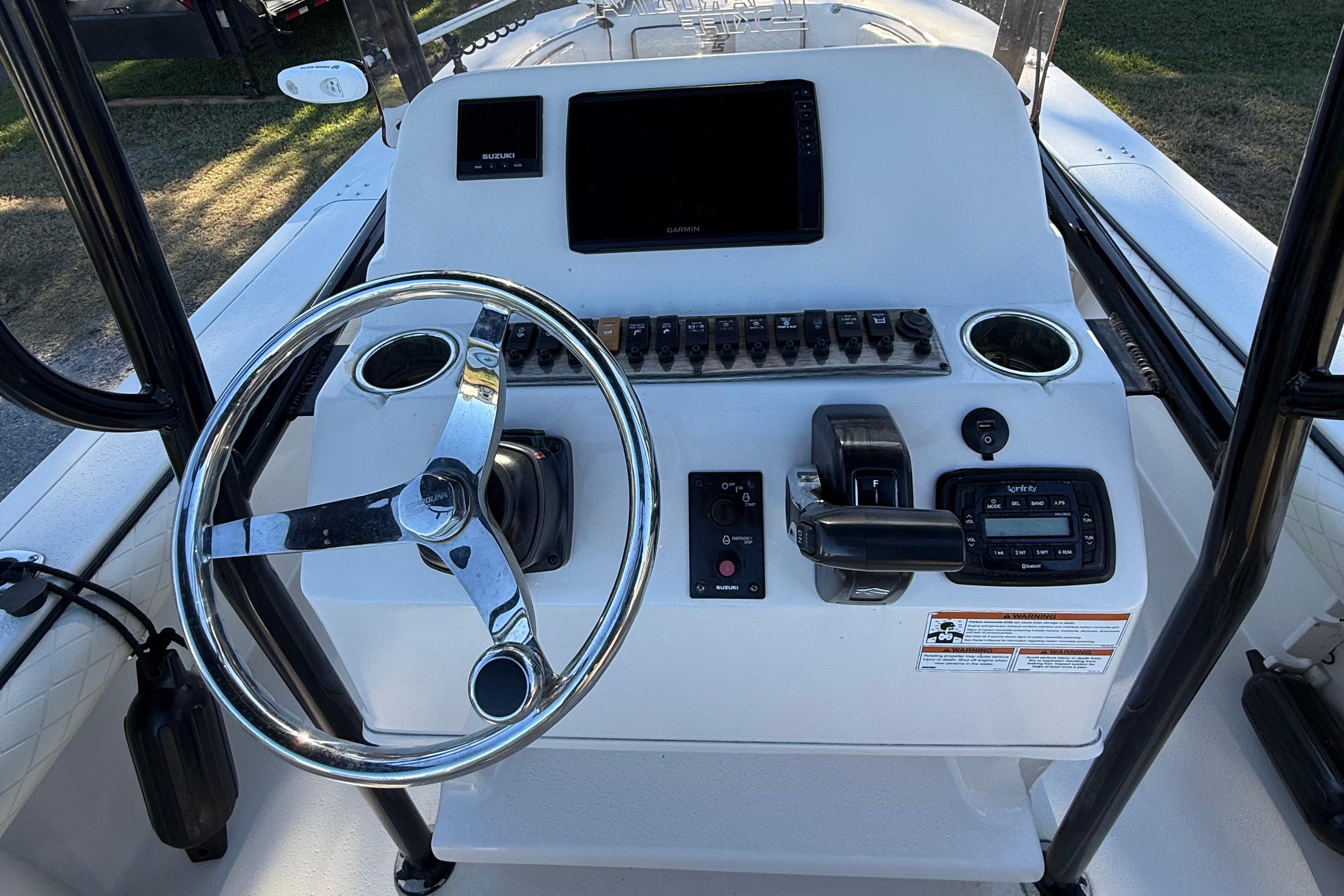 Control console of a 2021 Carolina Skiff 26 Ultra Elite boat with steering wheel and electronics.