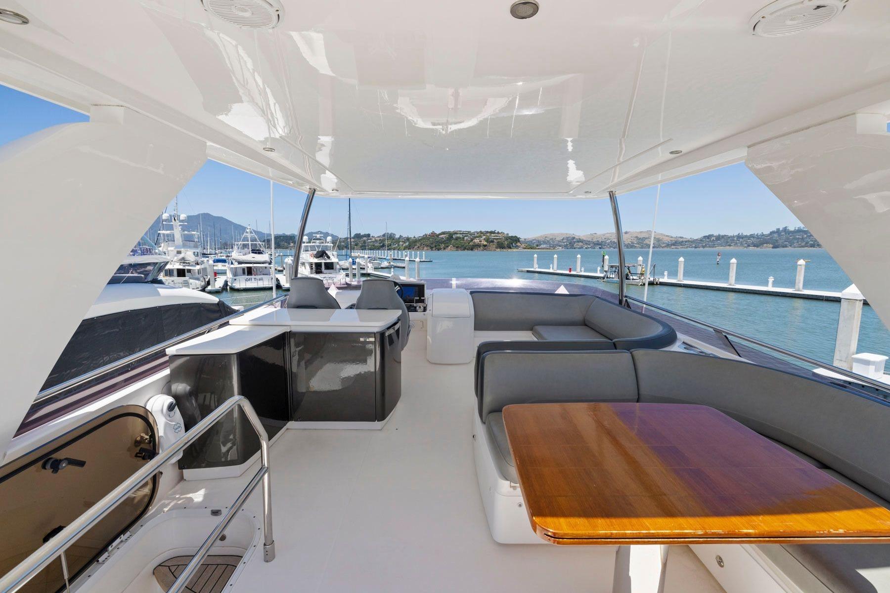Luxurious 2015 Princess 60 Flybridge Motor Yacht with spacious seating and scenic marina view.