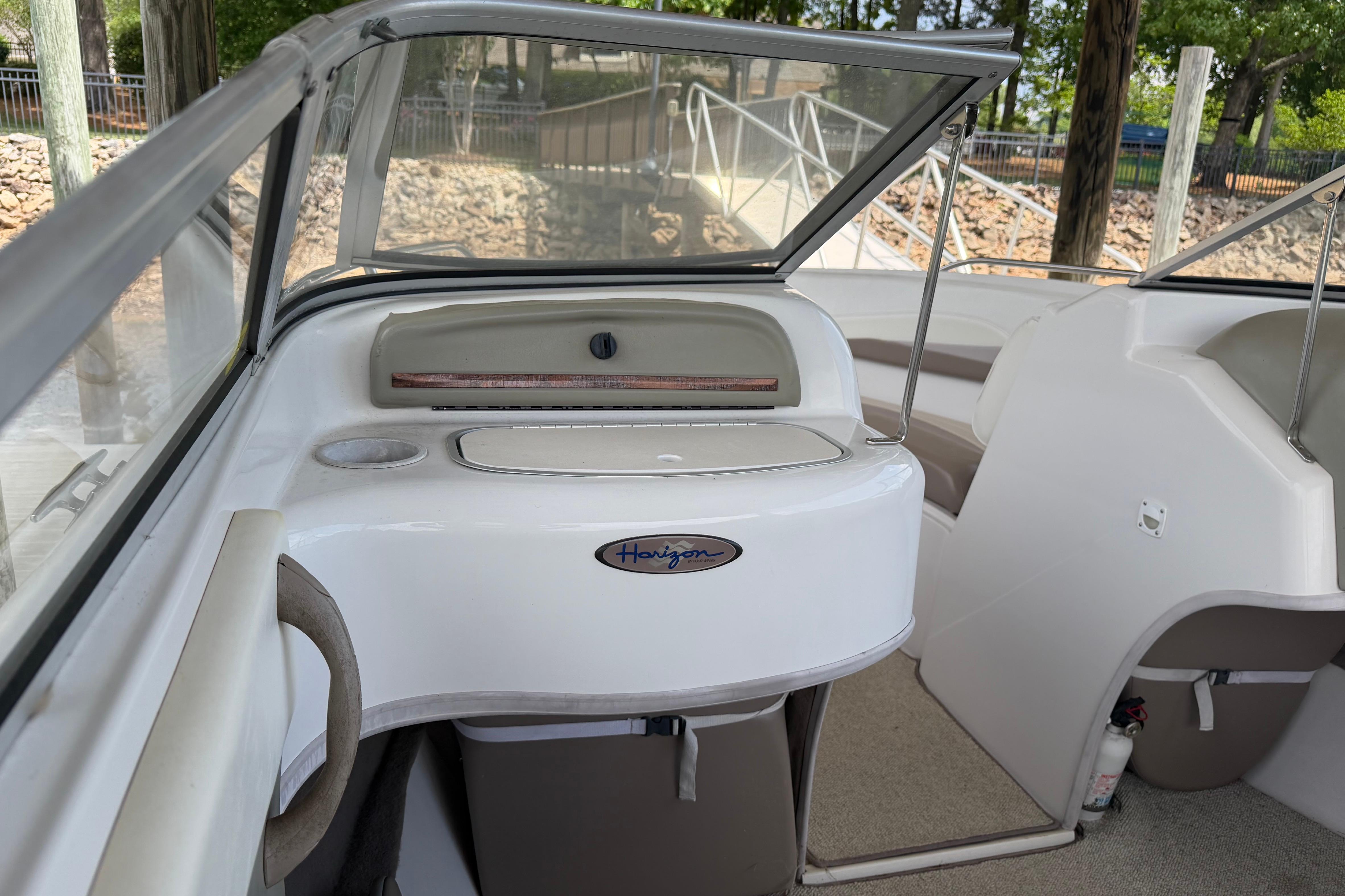Interior of a 1998 Four Winns 220 Horizon boat, featuring seating and storage areas.