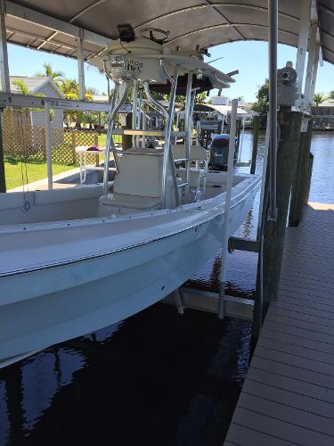 A 2011 Andros 26 Tarpon boat docked in a covered area by the water.