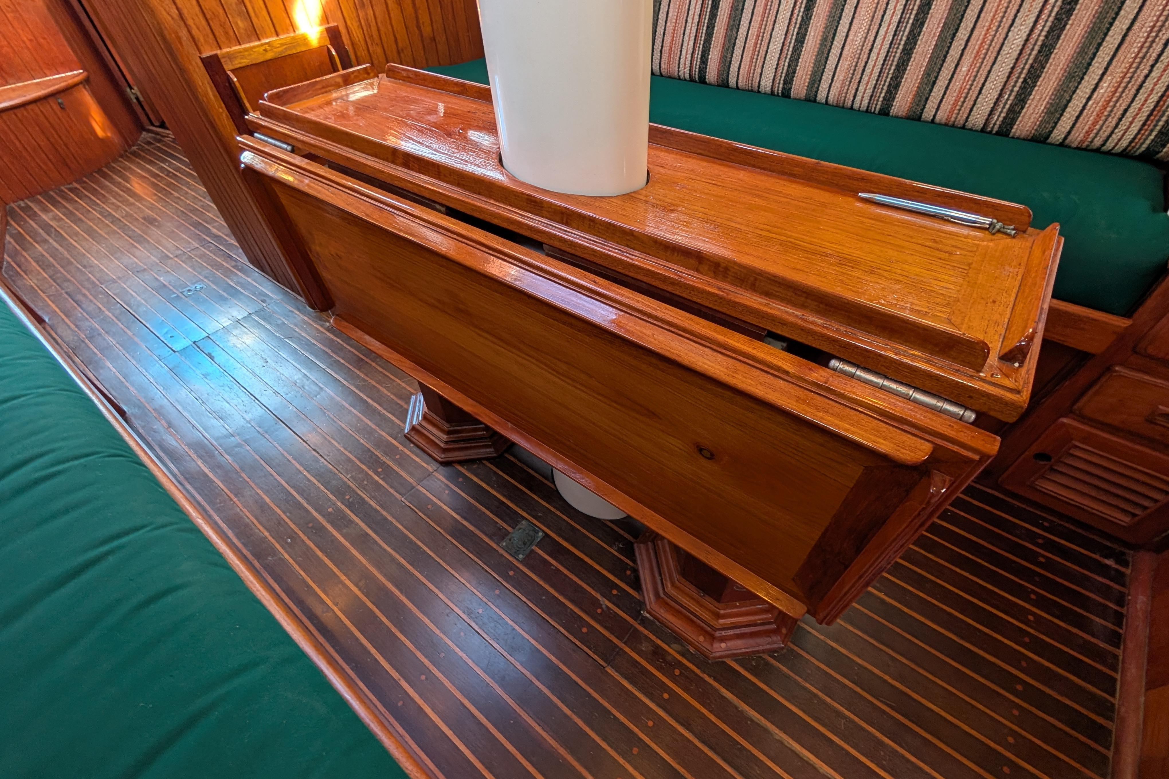 Interior of 1983 Robert Perry 41 yacht with wooden table and striped seating.