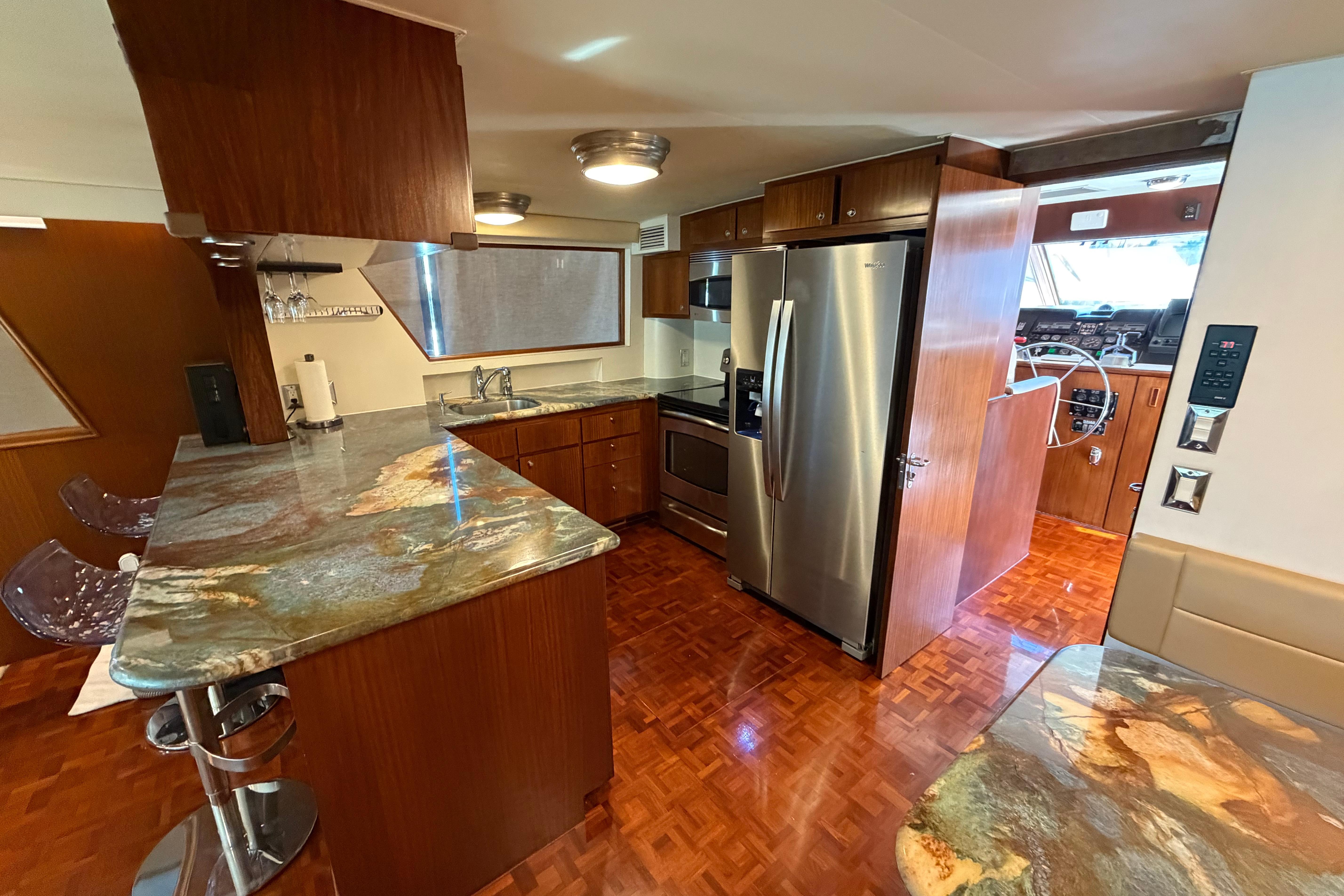 Luxurious kitchen interior of 1991 Hatteras 70 Motor Yacht with modern appliances.