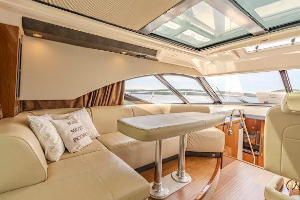 Luxurious interior of 2016 Sea Ray Sundancer 510 yacht with plush seating and panoramic windows.