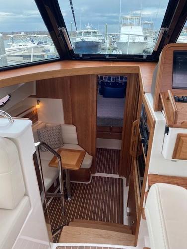 Interior of 2025 Back Cove 39O yacht with wooden finishes and cozy seating area.
