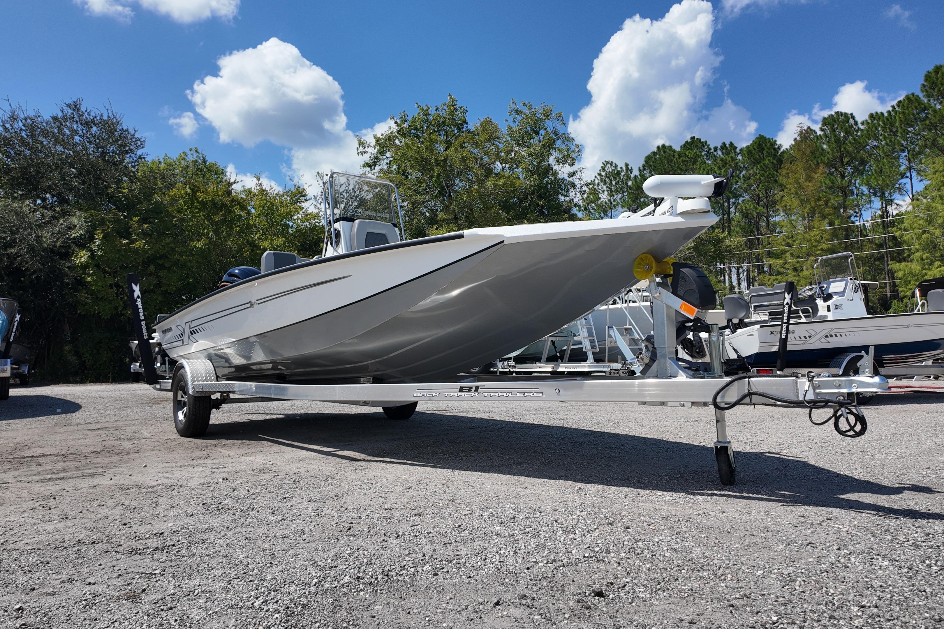 2026 Xpress H20 boat on trailer under blue sky with clouds.