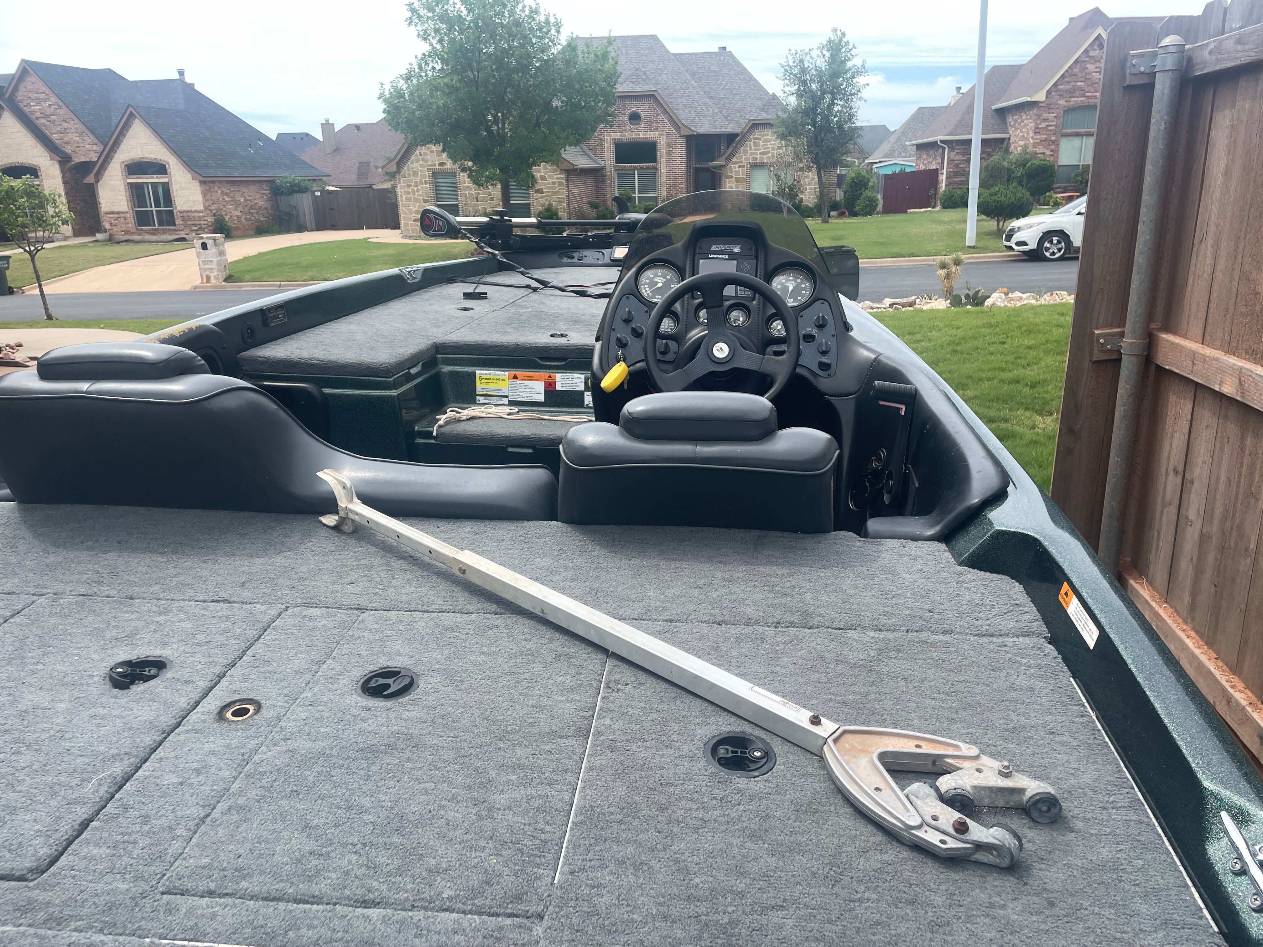 Stratos 19 SS from 2000 with gray carpeted deck and steering console, parked in a residential area.
