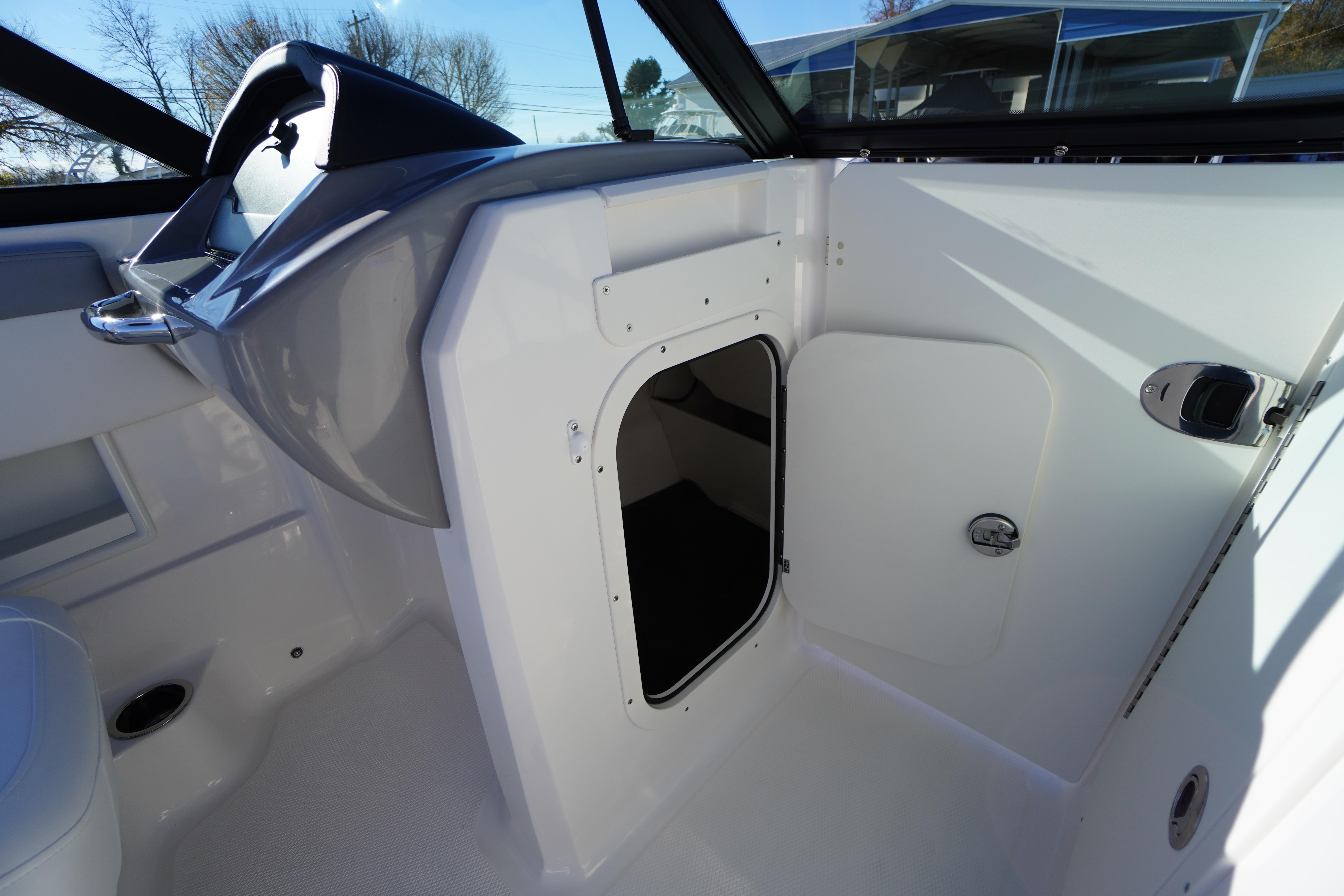 2026 Chaparral 23 SSi boat interior with storage compartment and steering wheel.