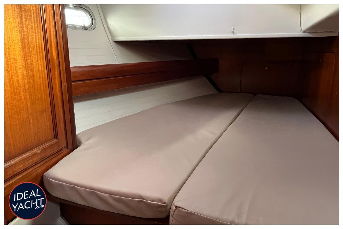 1998 Dufour 50 Classic yacht cabin with wooden interior and cushioned bed.