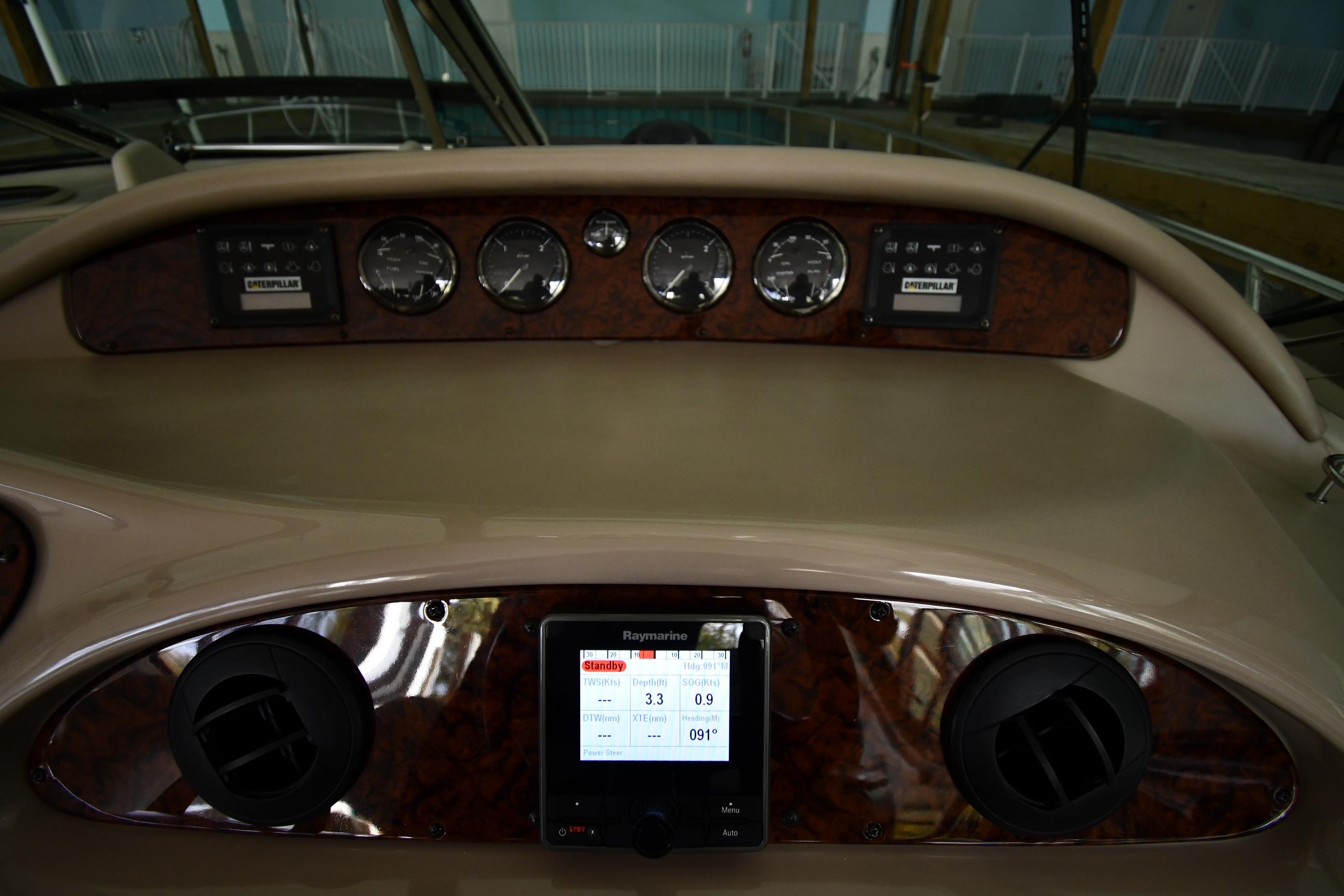 Helm dashboard of 2001 Sea Ray 540 Sundancer with gauges and Raymarine display.