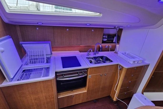 Modern yacht kitchen with wooden cabinetry, dual sinks, and appliances. Maxi 1300, 2010 model.