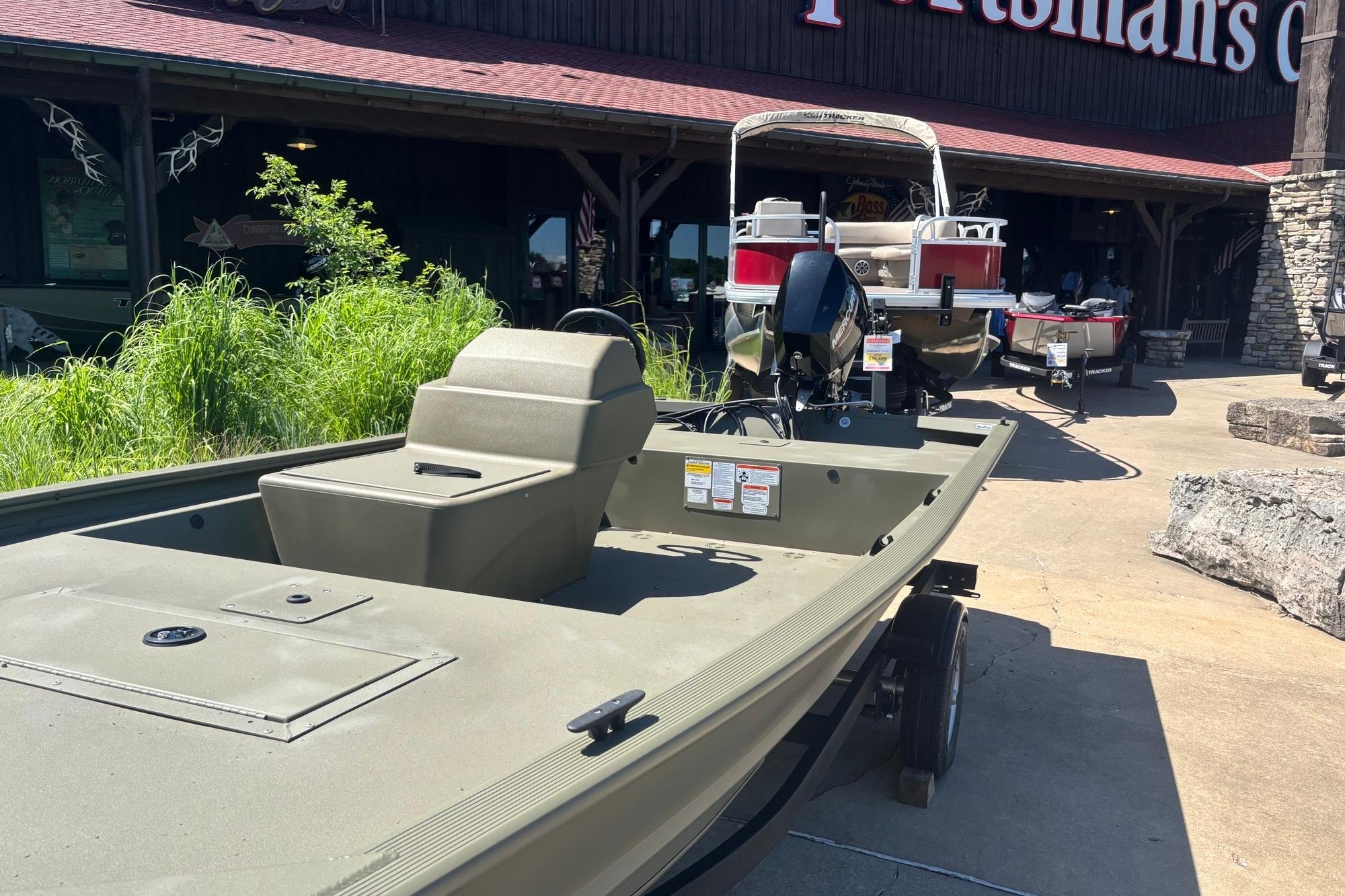2025 Tracker Grizzly 1648 SC boat displayed outside a store, sunny day.