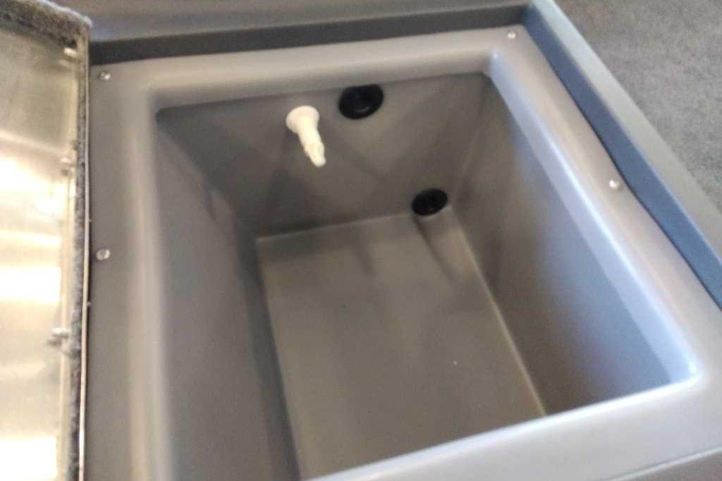 2026 Tracker Bass Tracker Classic XL livewell interior, featuring a gray compartment with drainage outlets.