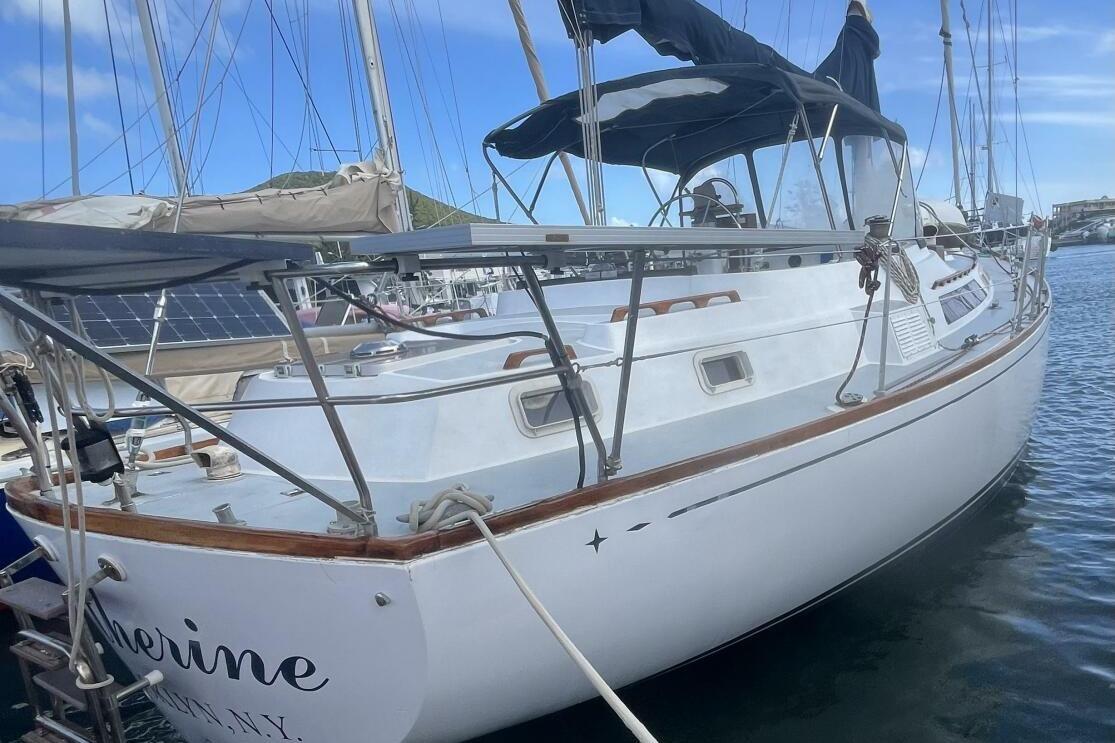 1982 C&C Landfall sailboat docked in marina, featuring sleek white hull and rigging.