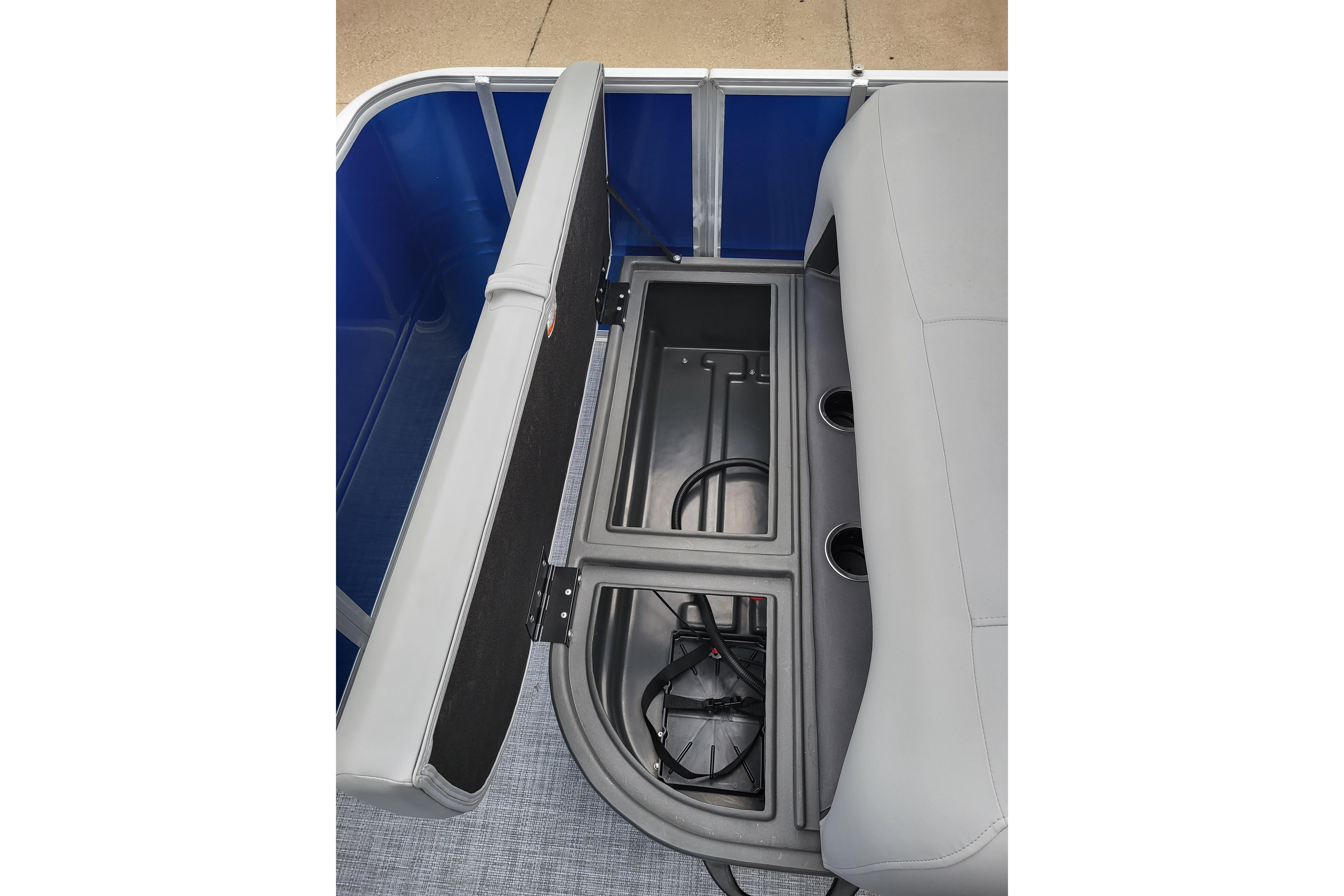 2026 Sun Tracker Party Barge 18 DLX storage compartment with gray seating and cup holders.