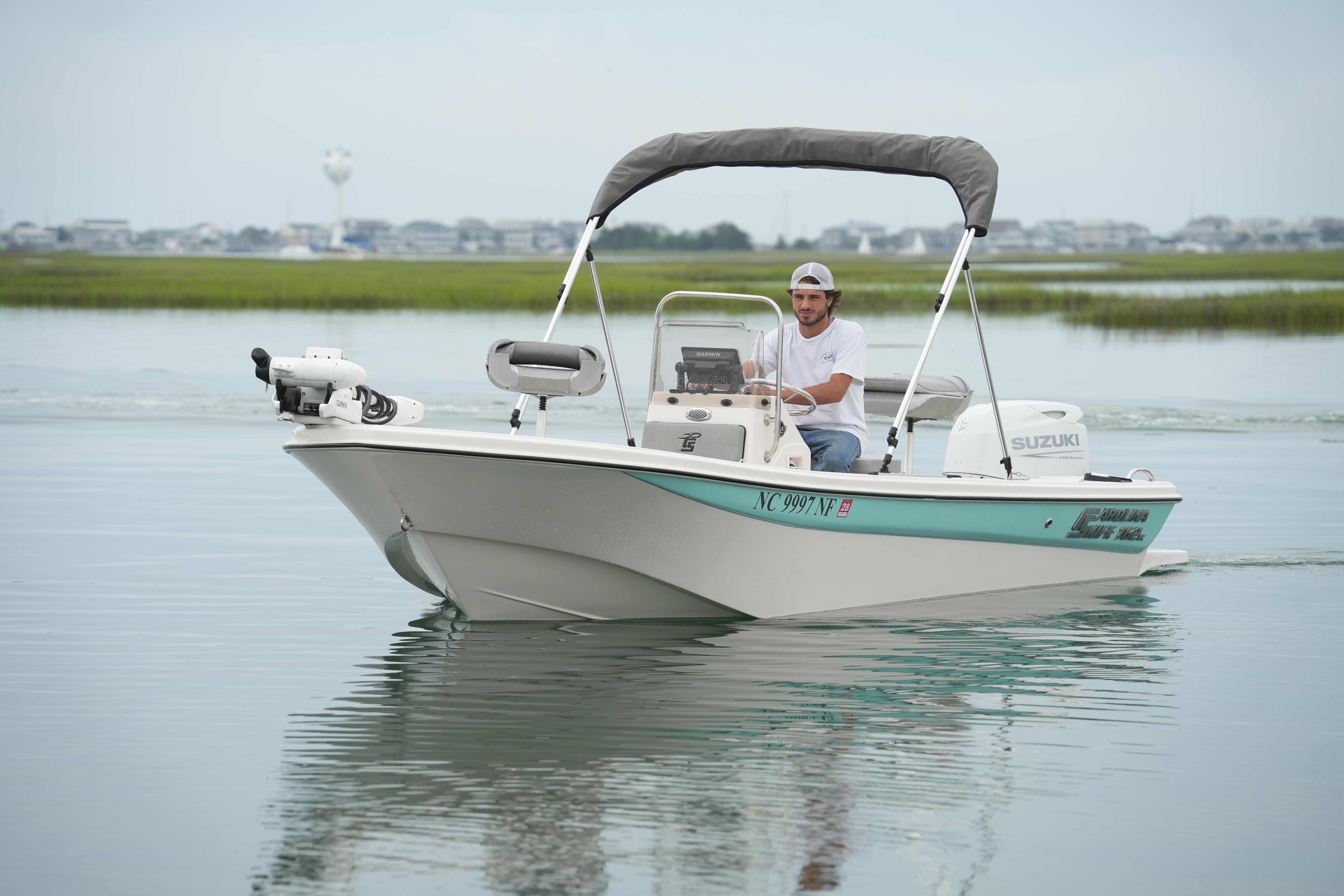 2025 Carolina Skiff 162 JLS boat cruising on calm water with a driver.