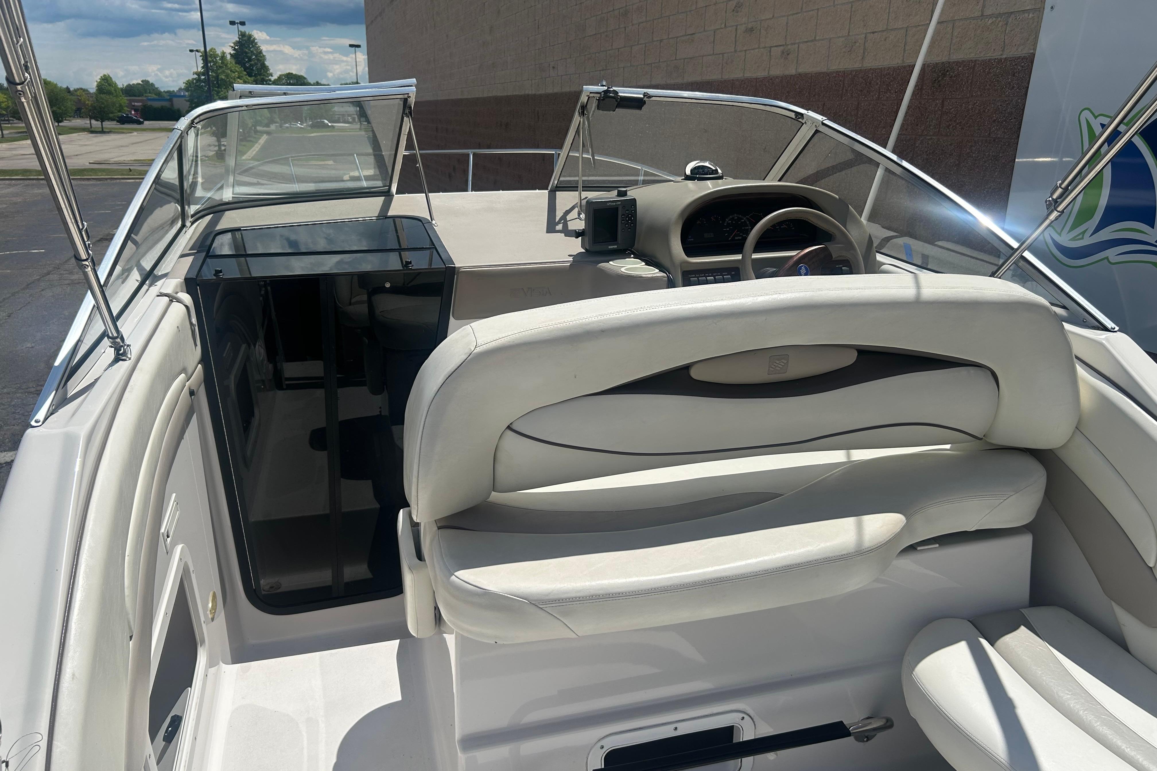 1998 Four Winns 258 Vista boat interior with white seating and steering console.