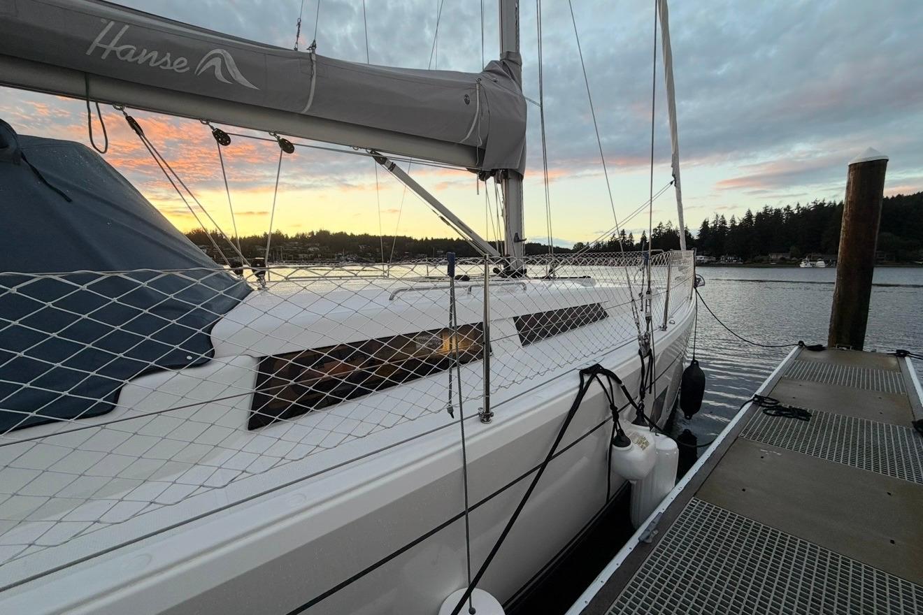 Sailboat Hanse 418, 2022 model, docked at sunset with scenic water view.