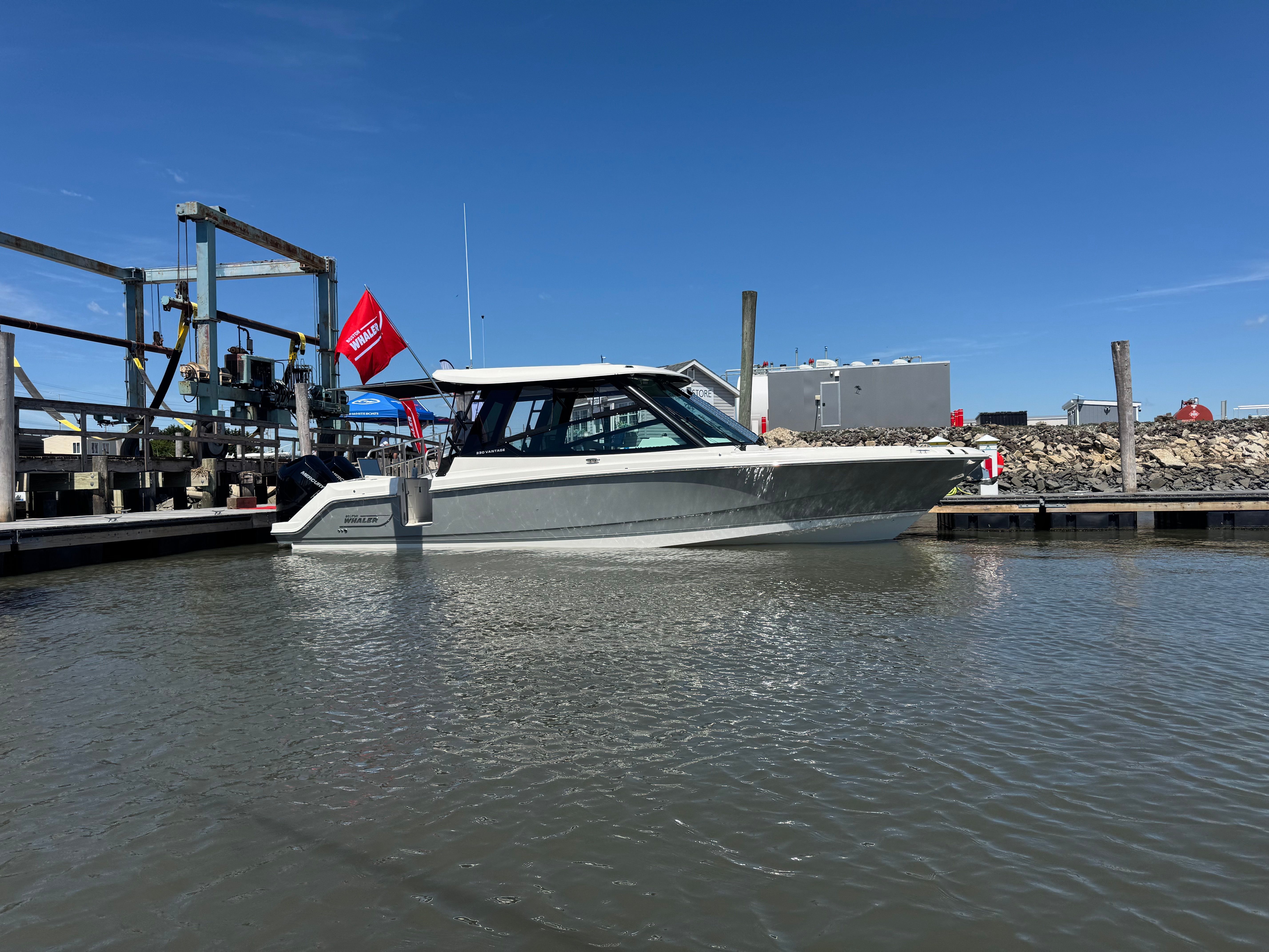 2025 Boston Whaler 330 Vantage in the water at a dock.