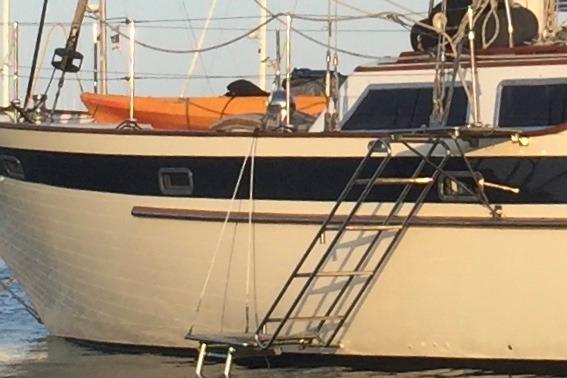 Sailboat Liberty 49, 1986 model, with a ladder and orange kayak on deck.