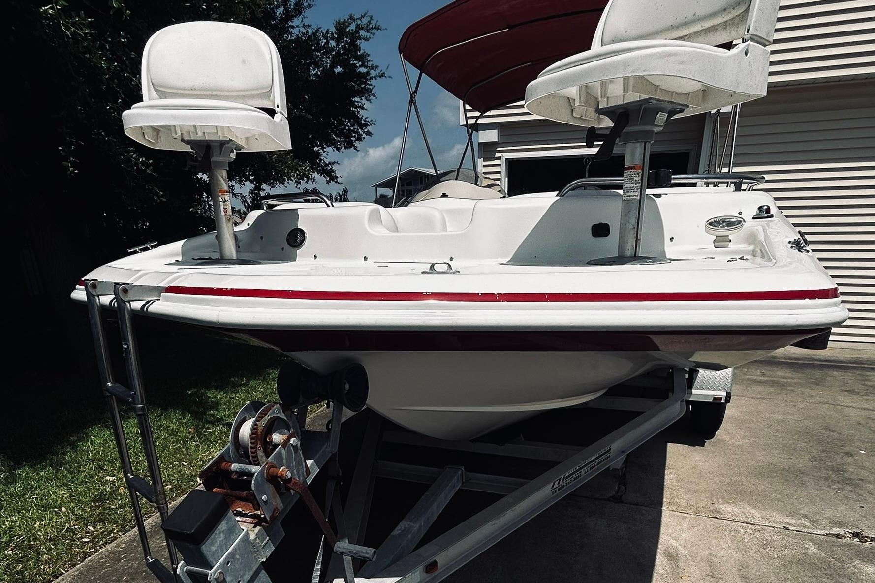2013 Hurricane SunDeck Sport 201 OB boat on trailer, featuring dual swivel seats.