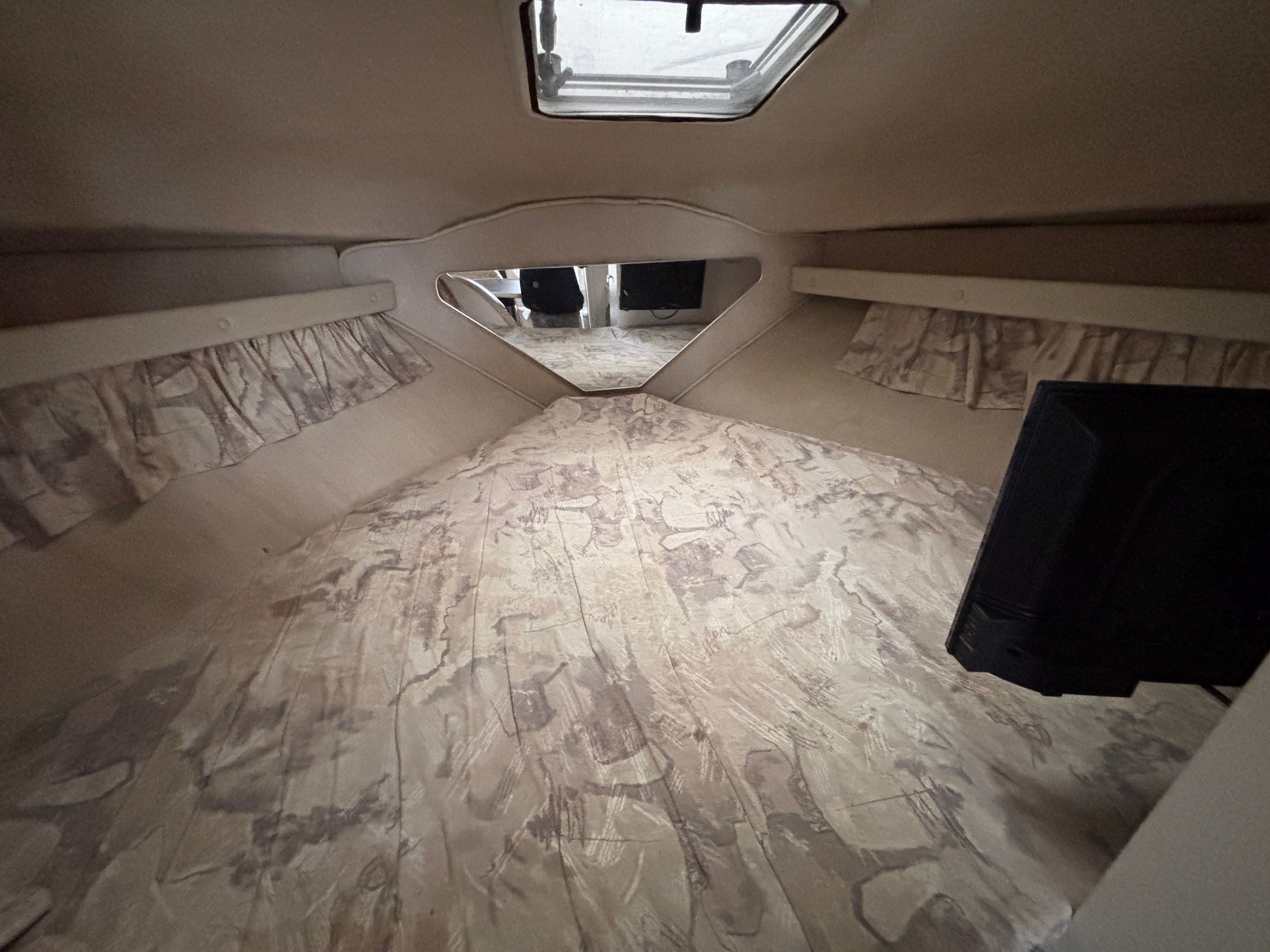 Interior of a Rinker Fiesta Vee 280 with sleeping area and skylight.