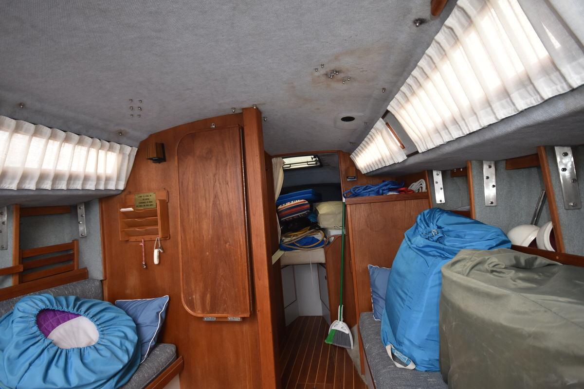 Interior of a 1987 S2 9.2A sailboat with wood paneling and cushions.