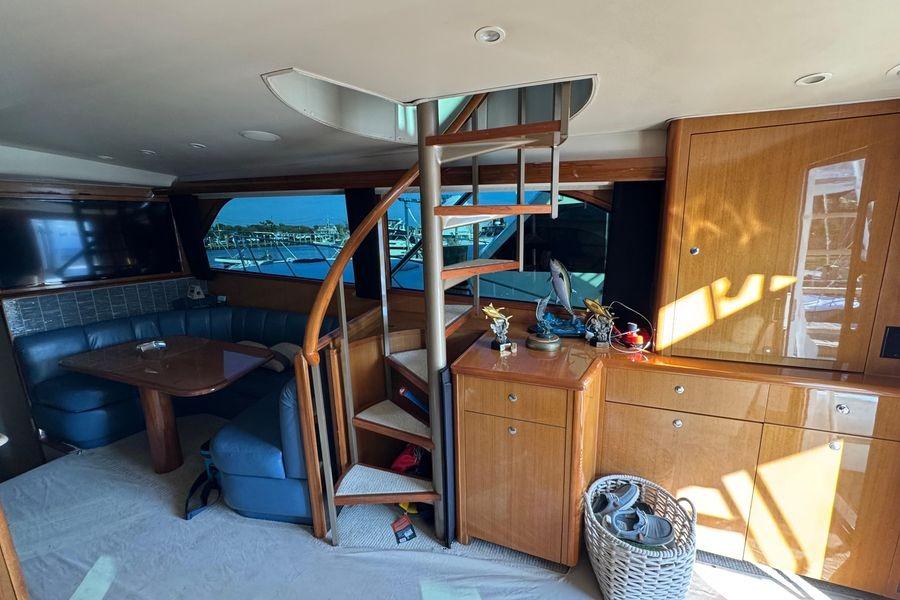 Interior of 2002 Viking 61 Enclosed Bridge yacht with spiral staircase and seating area.