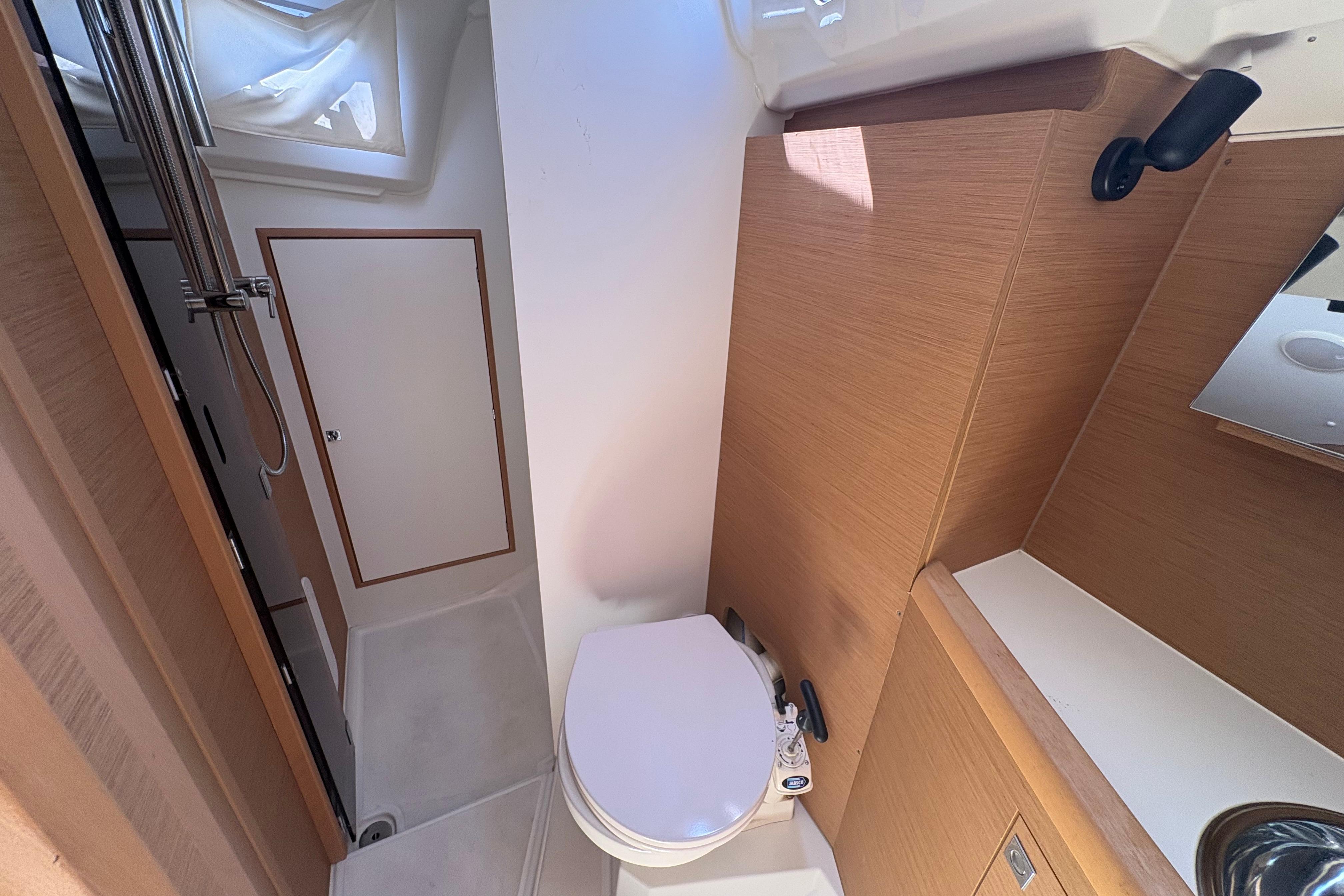 Interior of 2021 Jeanneau Sun Odyssey 349 yacht bathroom with shower and toilet.