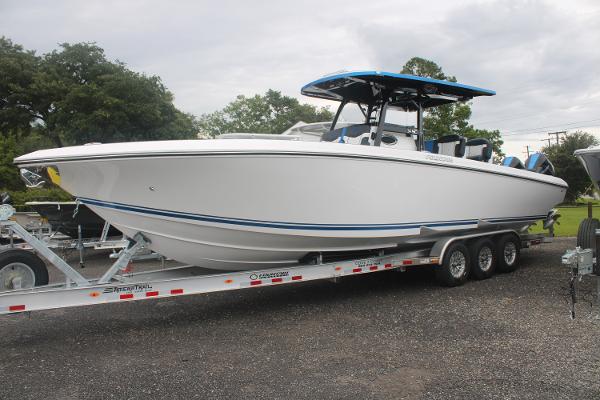 2024 Fountain 34 SC boat on trailer, white with blue accents, parked outdoors.