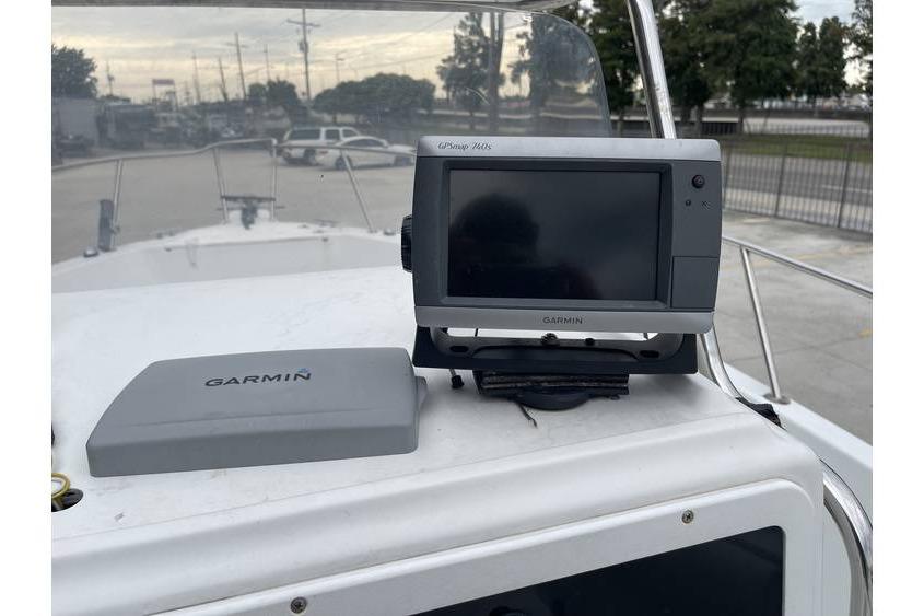 Garmin GPS device on 1998 Sunbird 230 CC boat dashboard, outdoor setting.