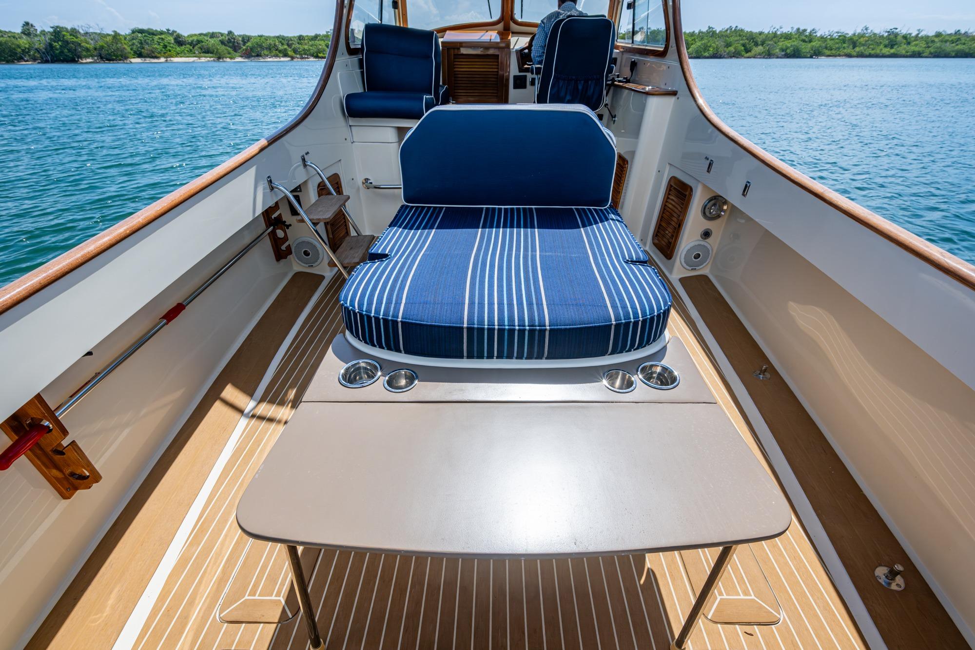2001 Hinckley Picnic Boat Classic interior with striped seating and table on calm water.