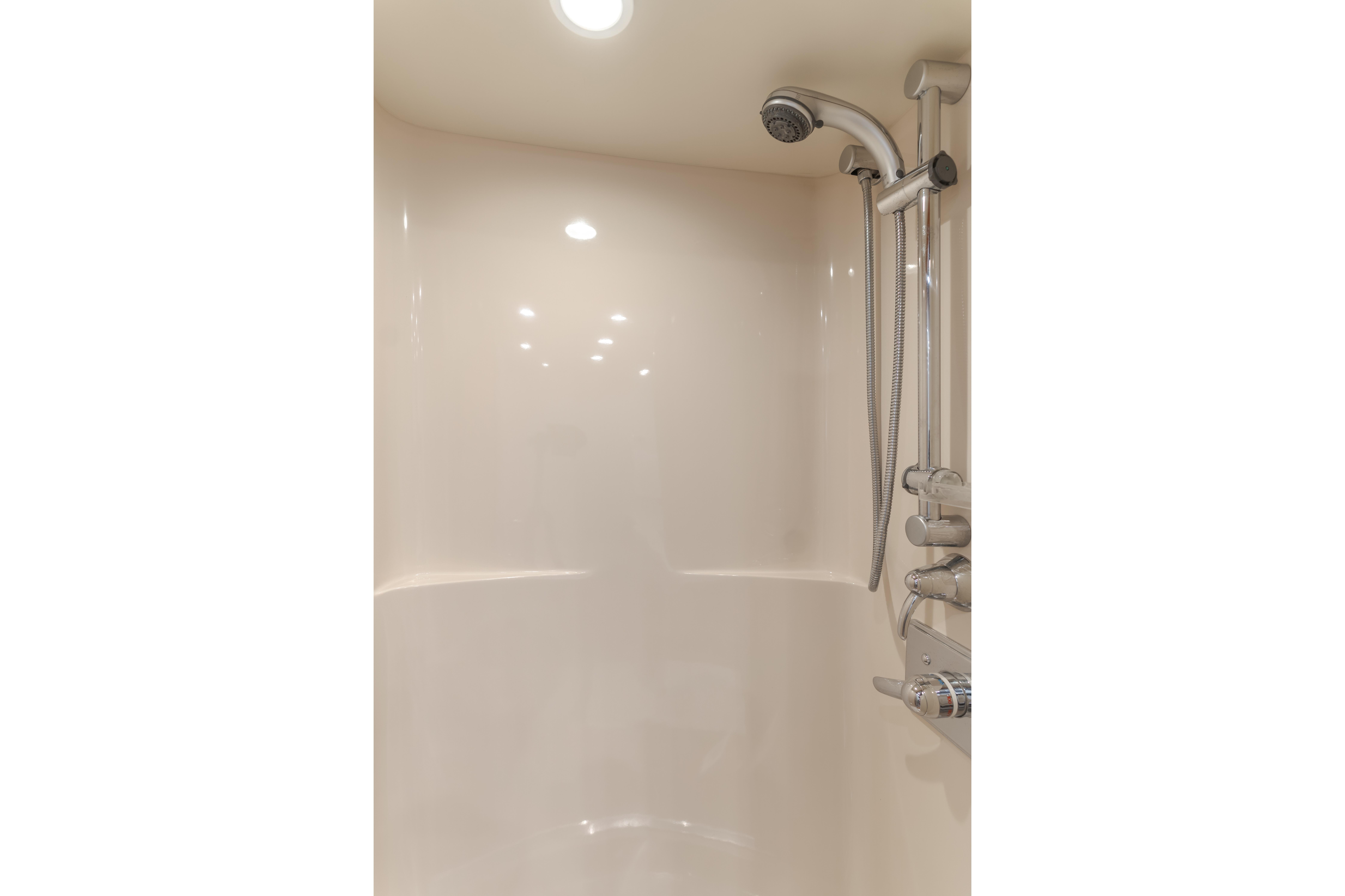 Luxurious shower in 2006 West Bay 64 yacht, featuring modern fixtures and lighting.