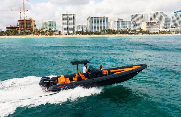 2024 Onda Magna boat cruising near a city shoreline with skyscrapers.