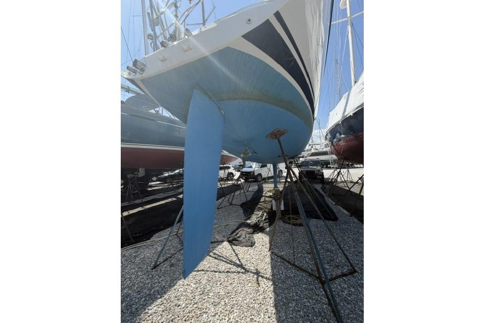2002 Saga 43 sailboat on stands, showcasing blue hull and keel in a boatyard.