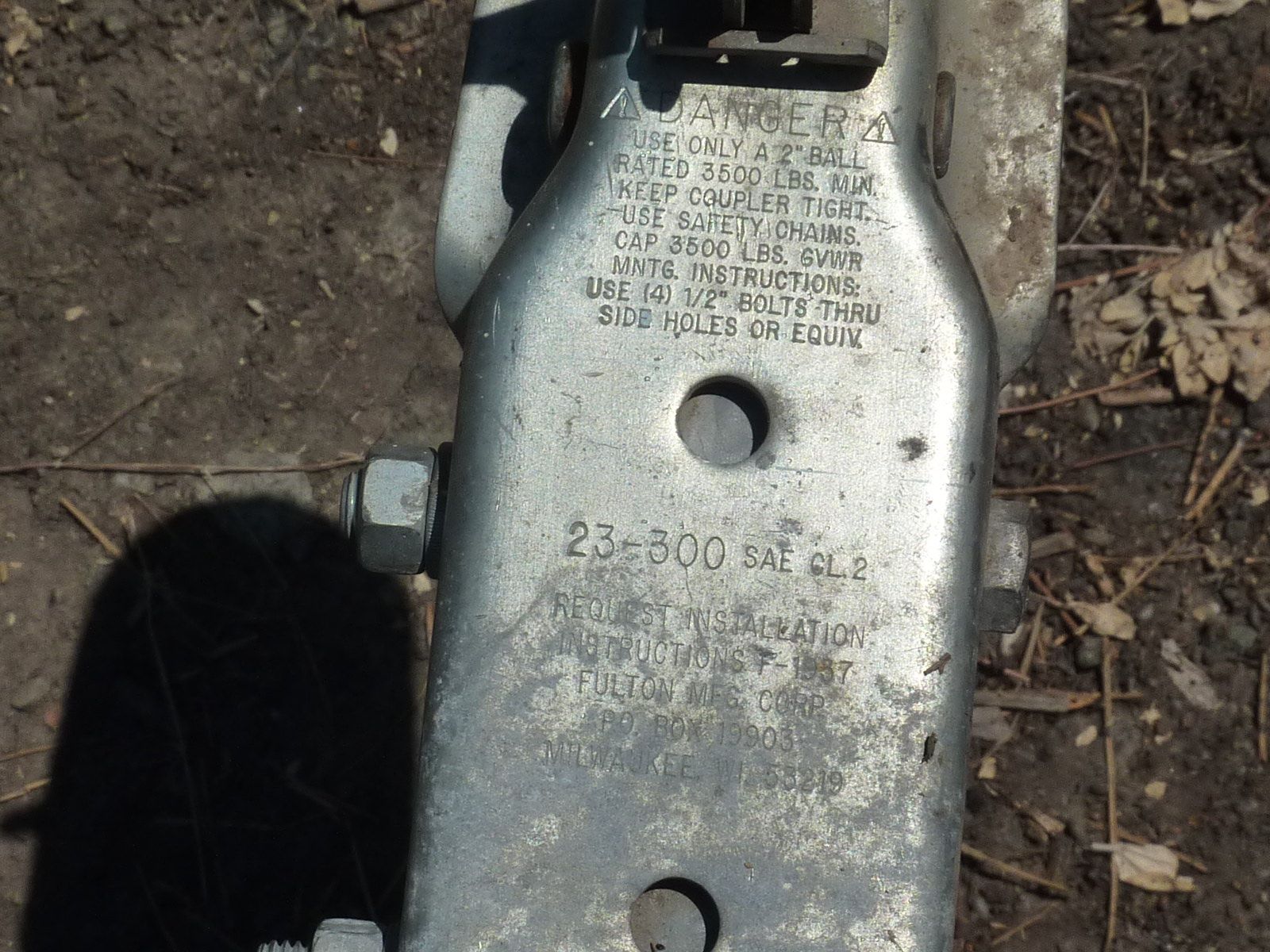 Close-up of a trailer hitch with safety and weight instructions.