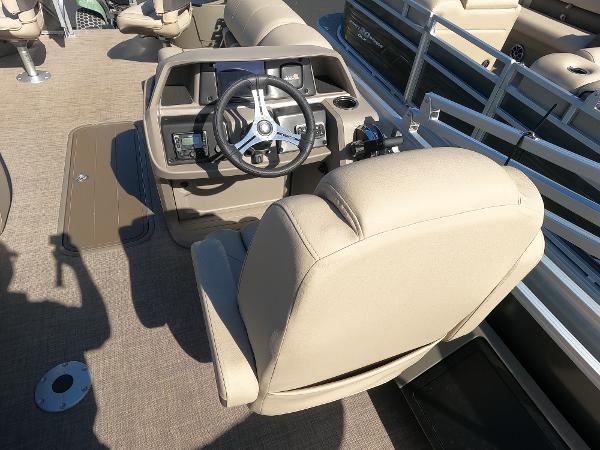 2024 Sun Tracker Fishin' Barge 22 XP3 helm station with beige captain's chair and steering wheel.